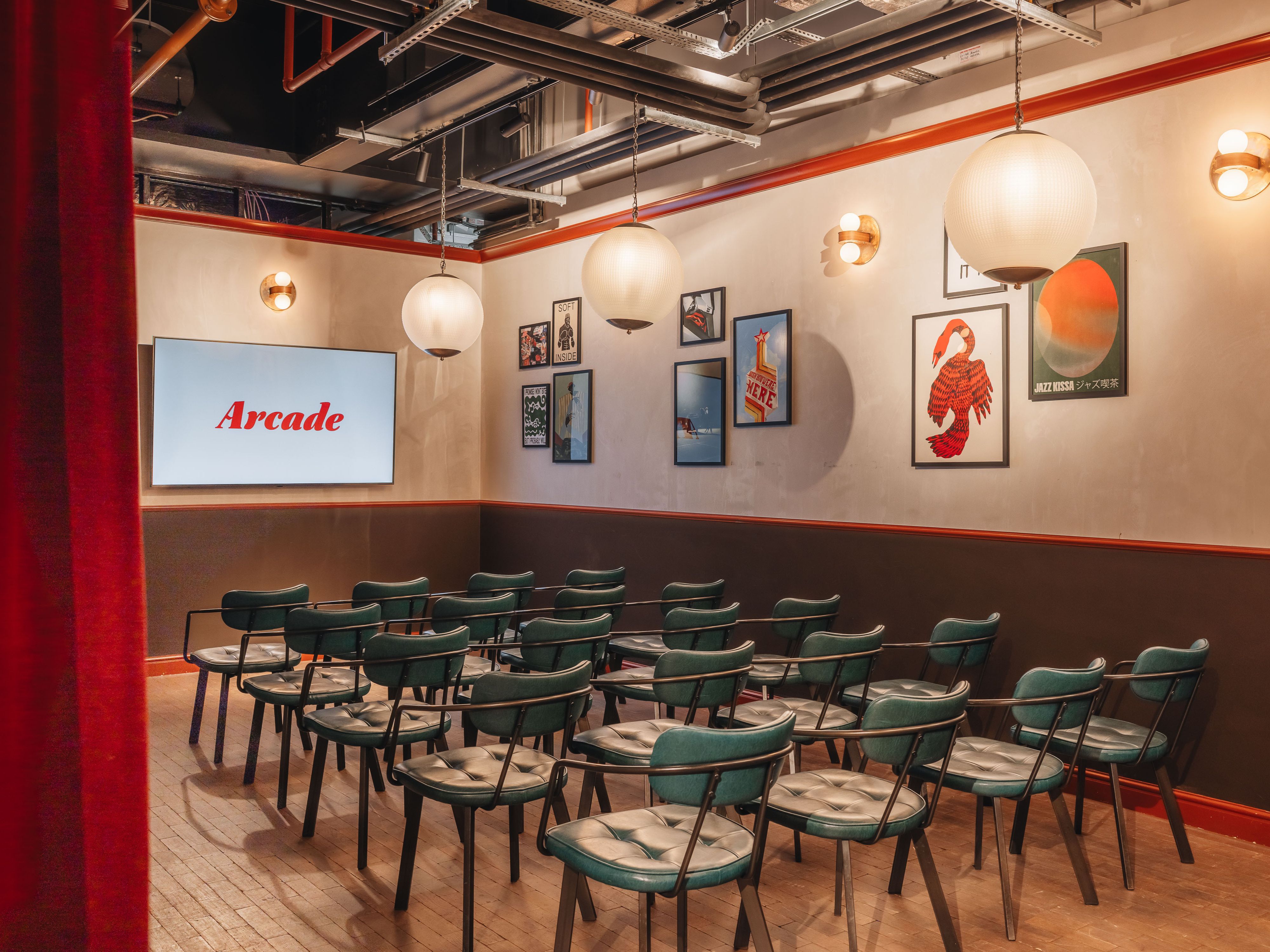 Stylish private room for meetings, featuring rows of chairs and large screen at Arcade Battersea.
