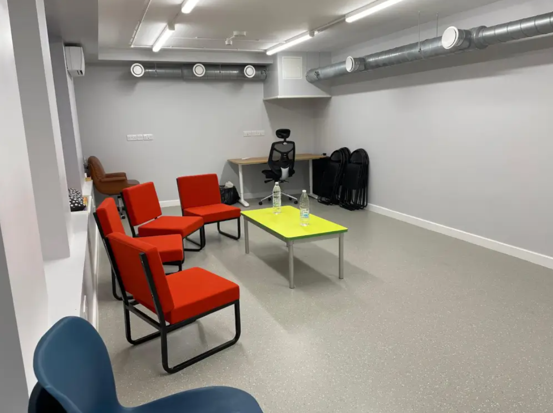 Modern meeting space at Ivy Street Family Centre with orange chairs for brainstorming sessions.