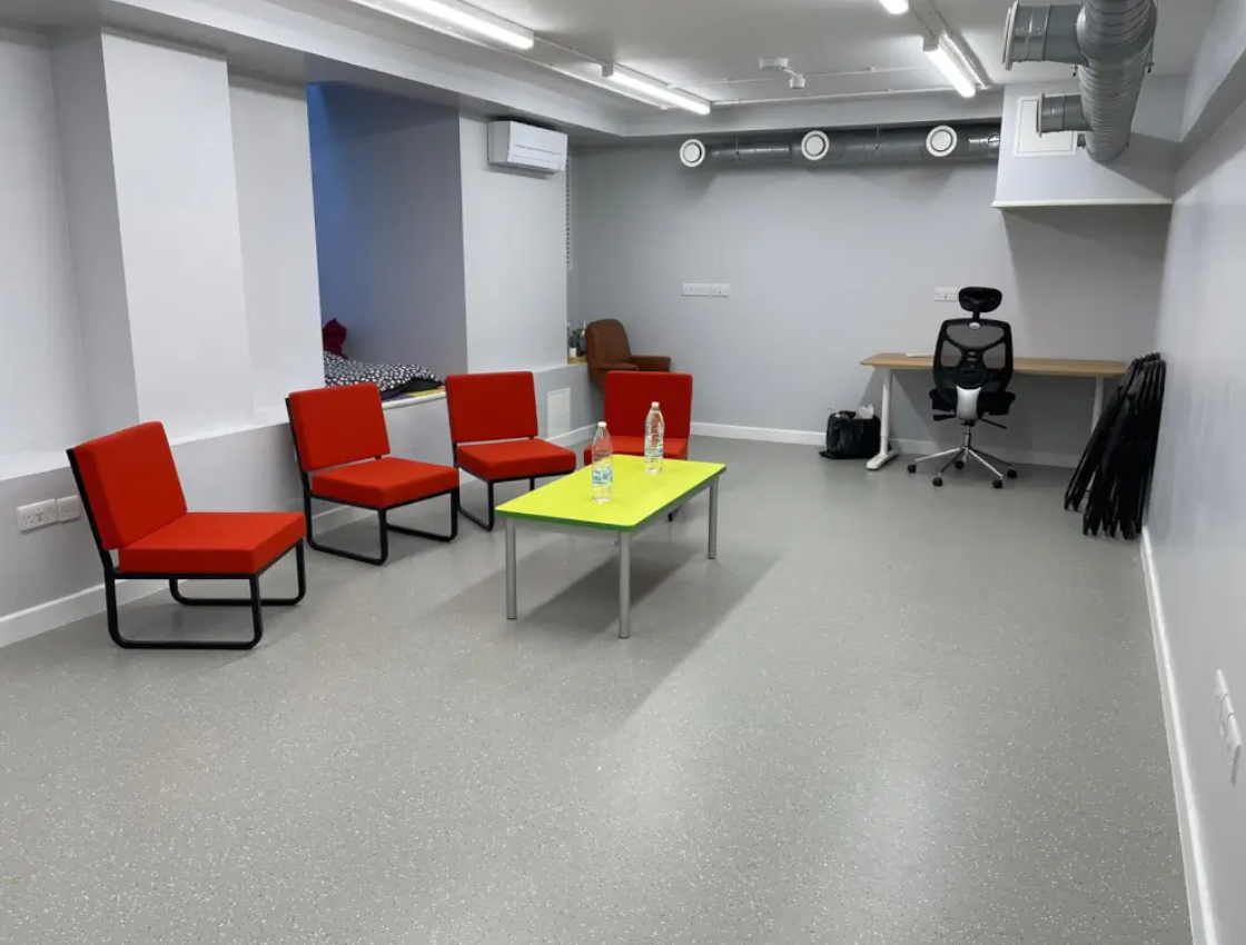 Meeting space at Ivy Street Family Centre with red seating for creative collaboration.