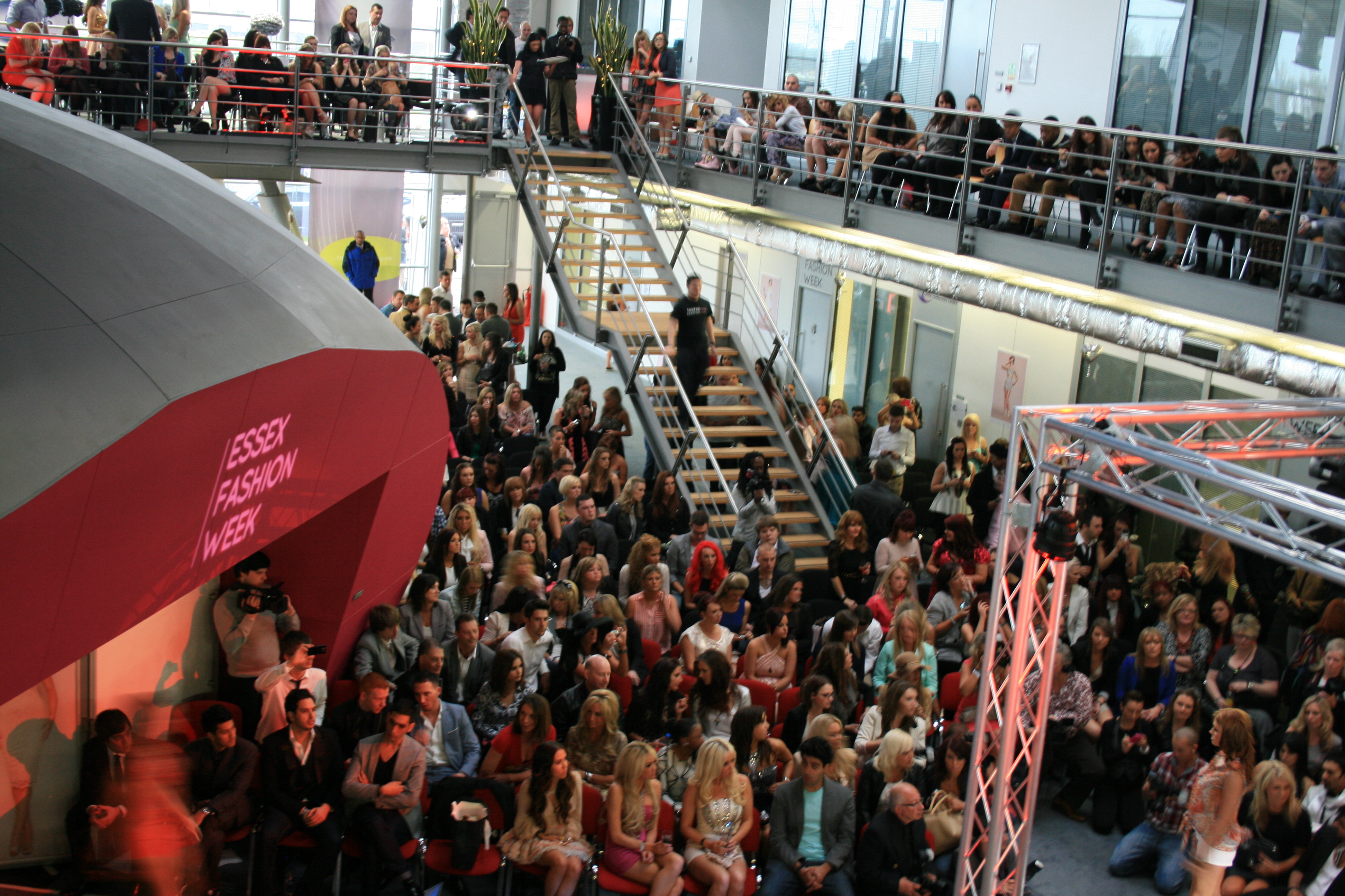 Atrium event space with tiered seating at a vibrant fashion show.