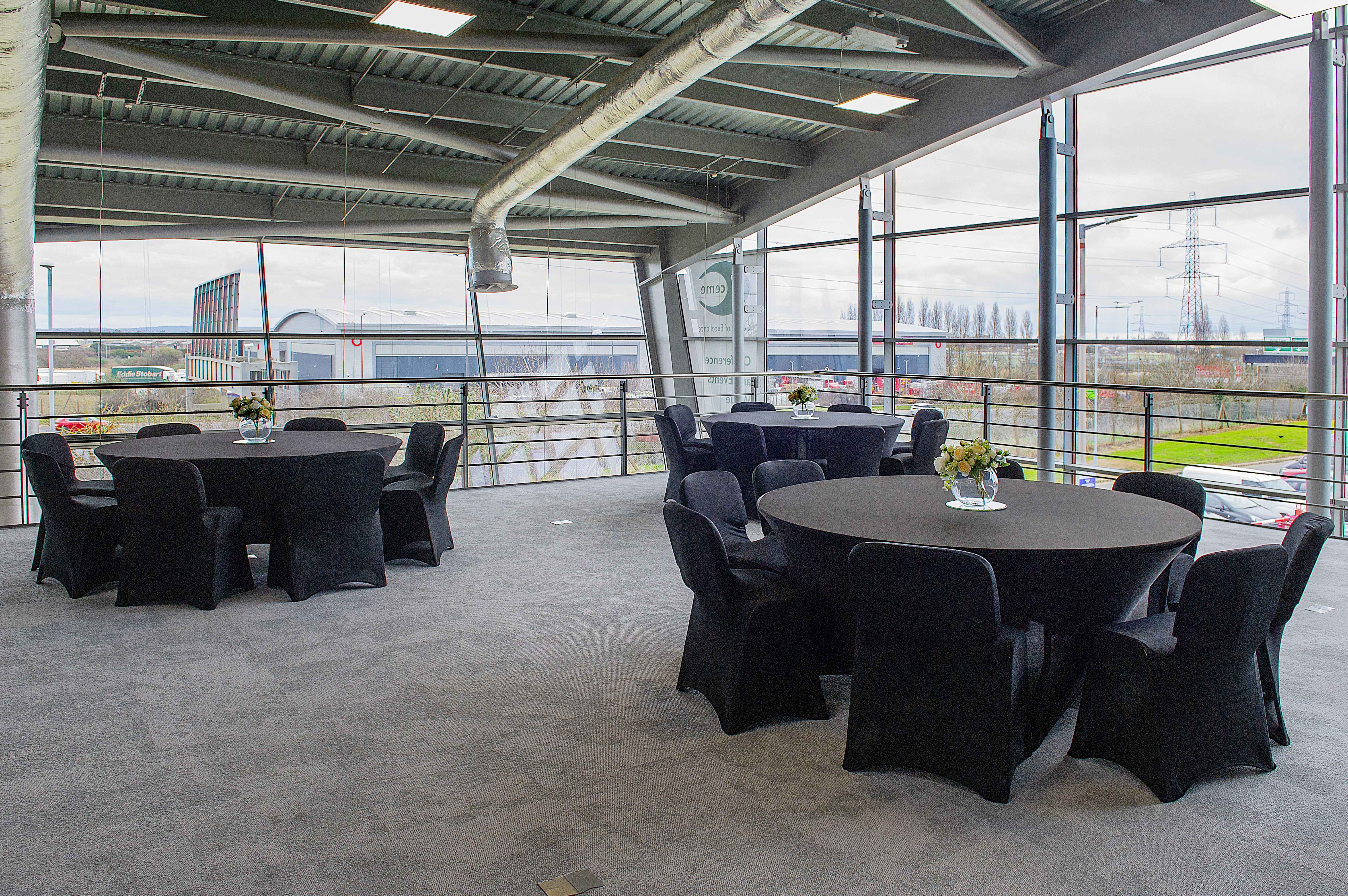 Modern event space with round tables and natural light at CEME Events.