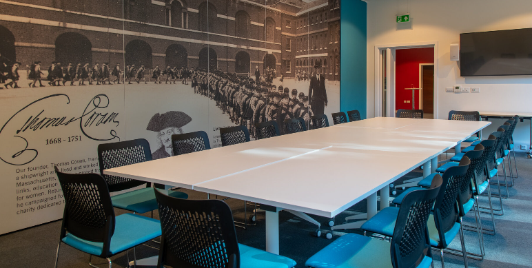 Modern conference room with white table and ergonomic chairs, ideal for corporate meetings.