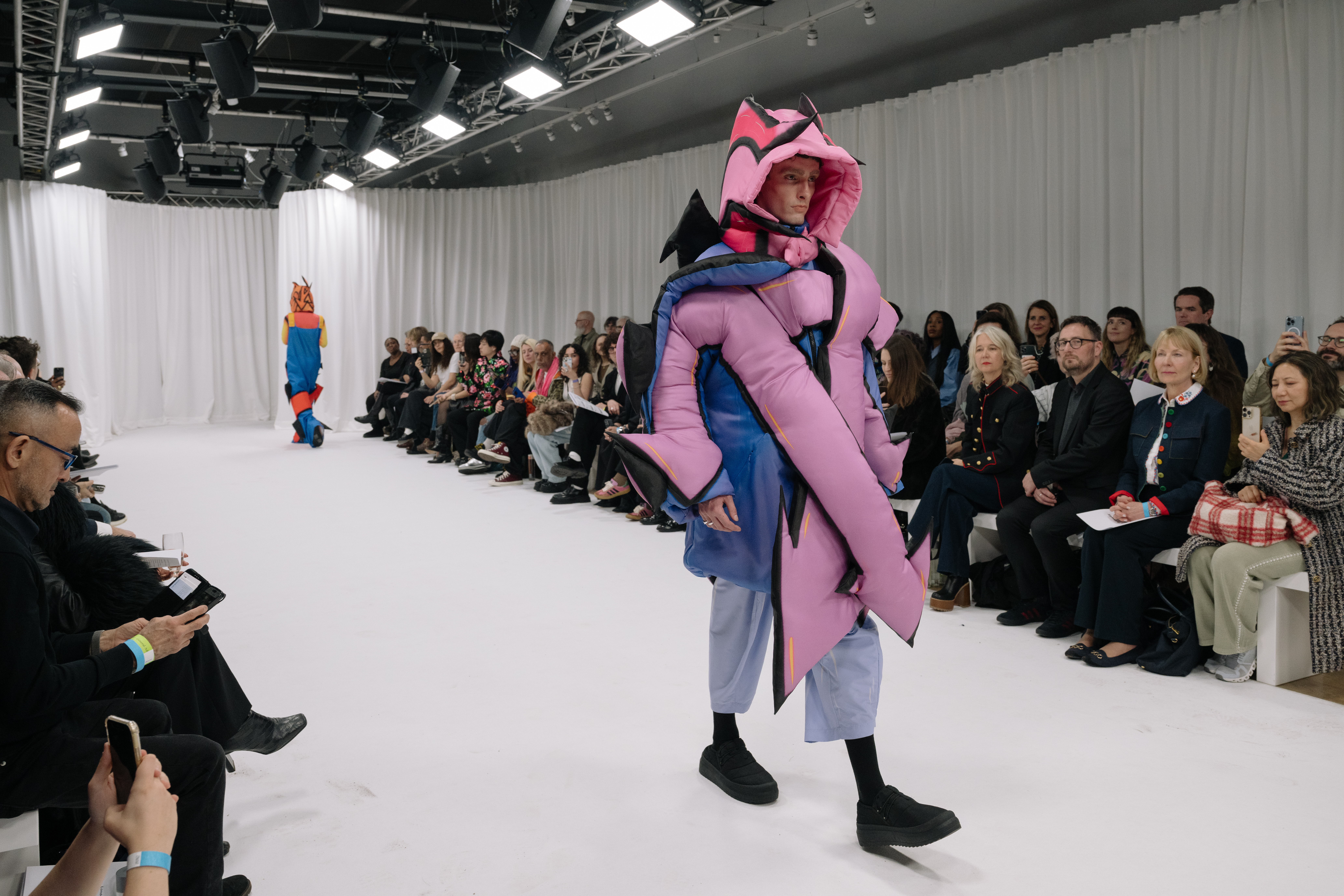 Dynamic runway fashion show with bold designs in a mall gallery.