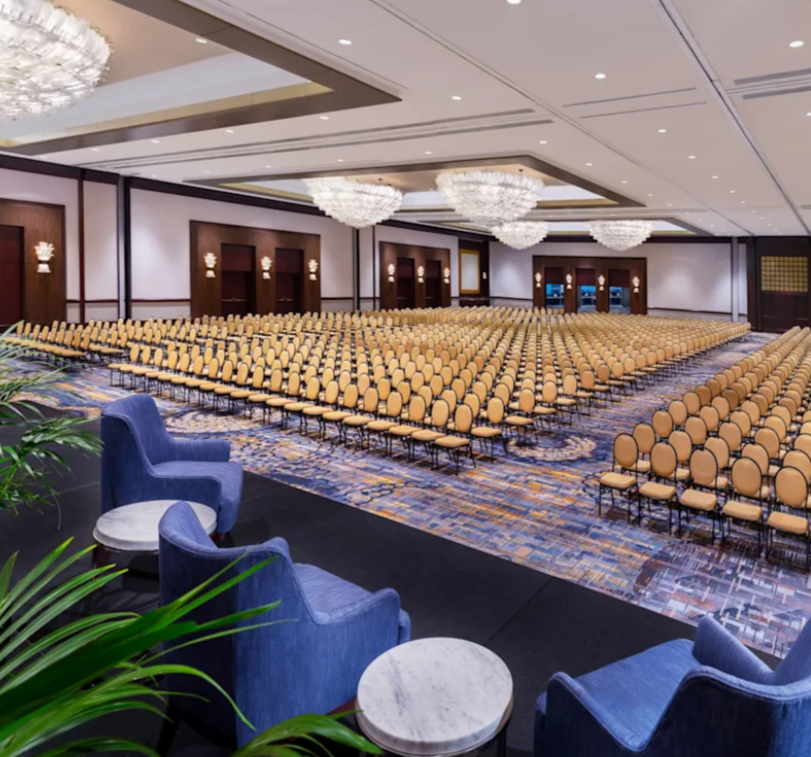 Ballroom of the Americas: elegant event space with blue armchairs for conferences.