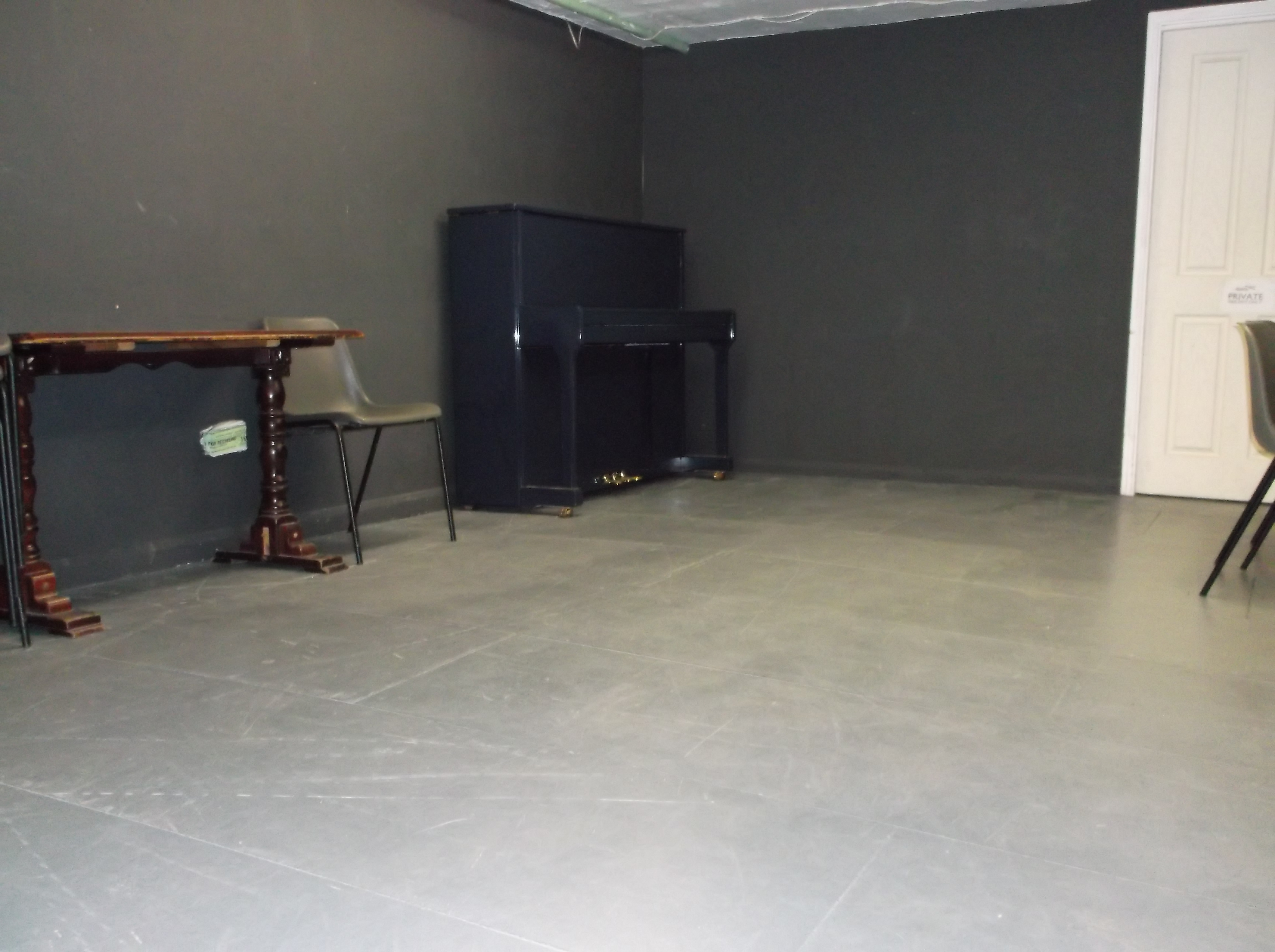 Minimalist event space with piano at The Basement, Calder Theatre Bookshop for workshops.