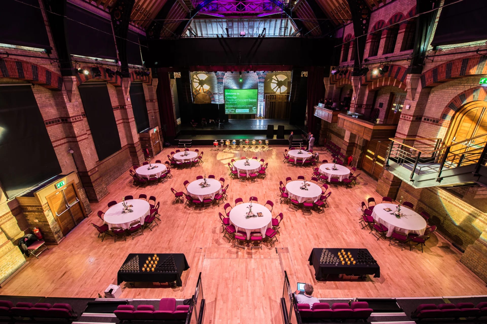 Gala dinner setup at Cambridge Corn Exchange with historic architecture and round table seating.