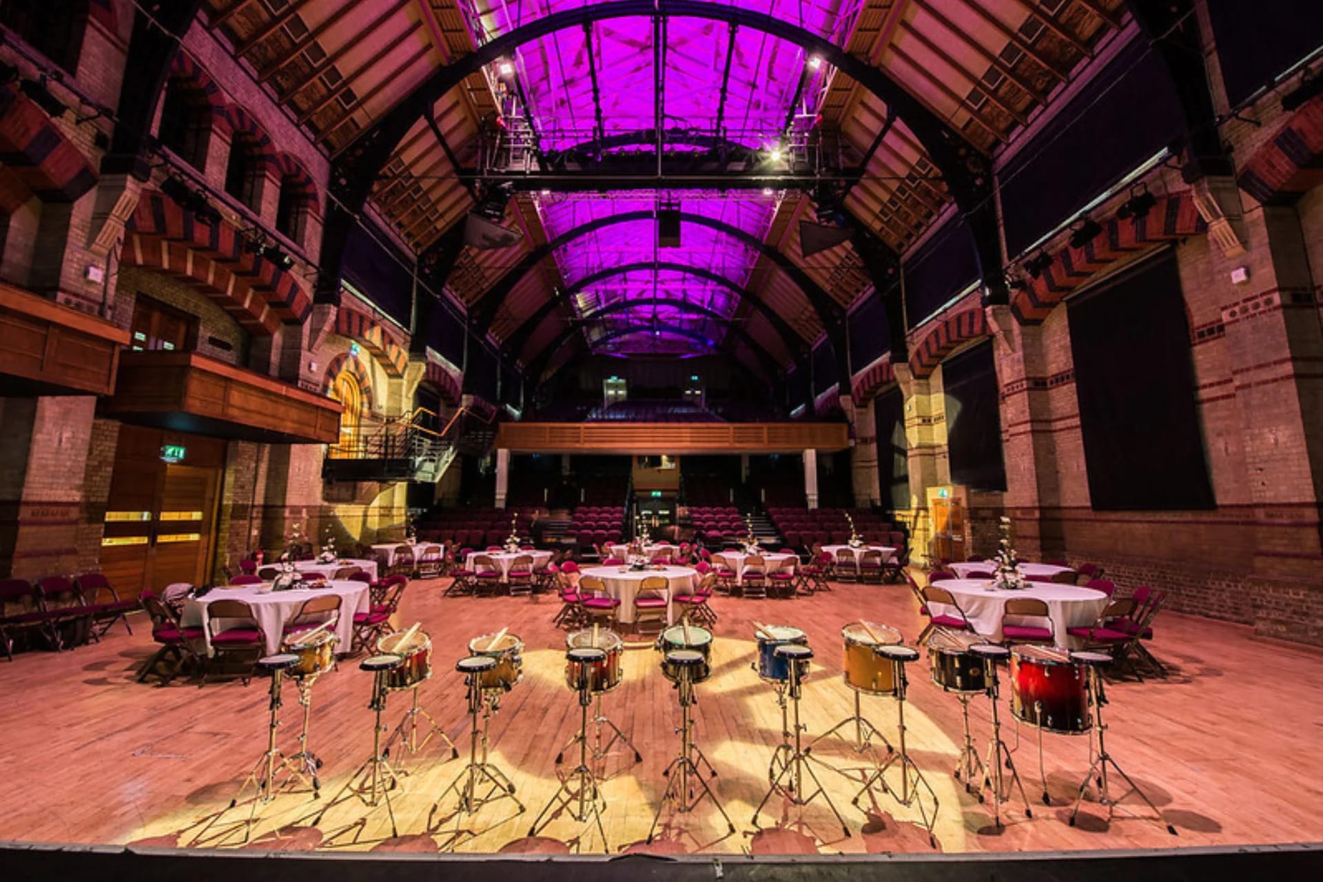 Main Auditorium at Cambridge Corn Exchange with purple uplighting for gala event staging.