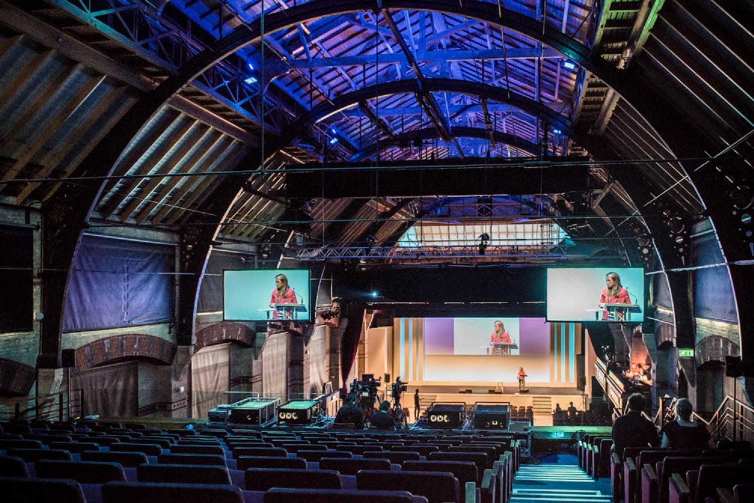 Keynote setup at Cambridge Corn Exchange with triple-screen AV for corporate conferences.