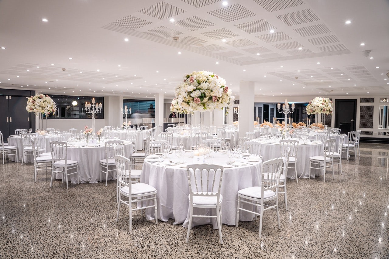 Elegant banquet space at Le Jardin, ideal for weddings and corporate events with floral centerpieces.