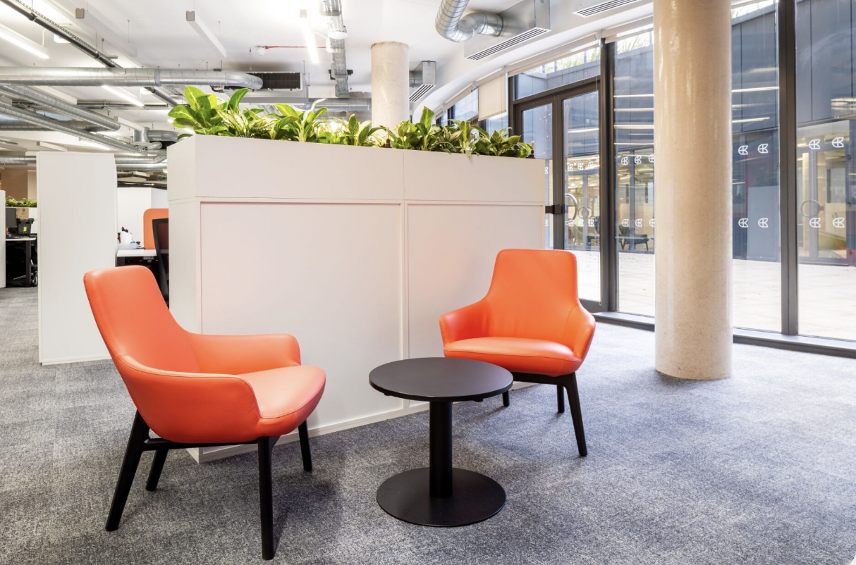 Modern event space with vibrant orange chairs for networking and meetings.