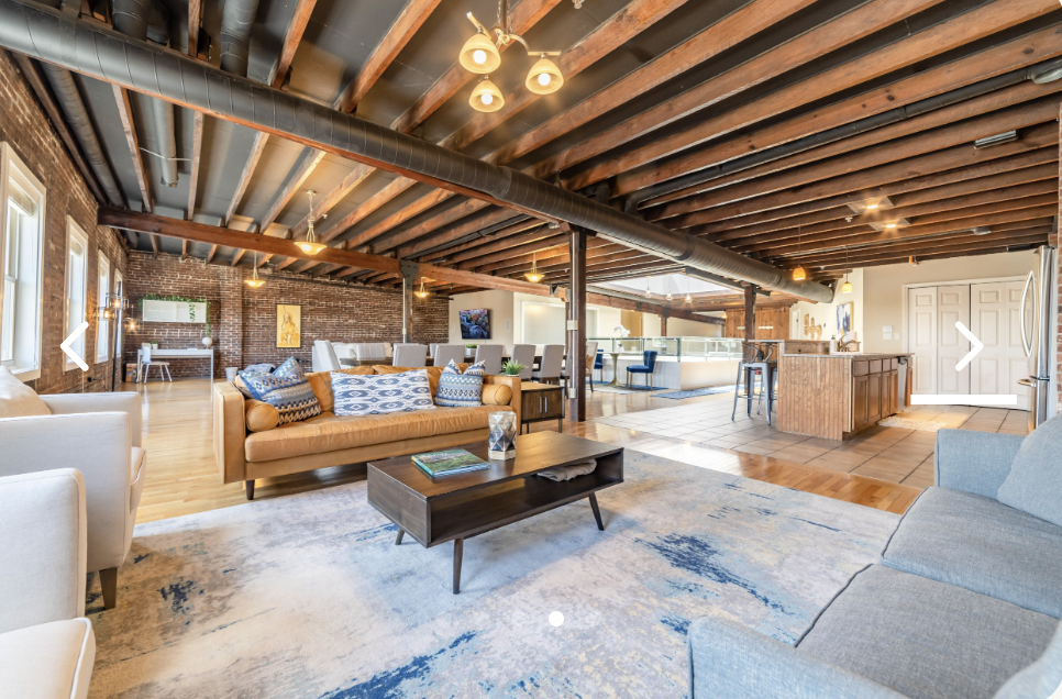 Spacious event space with exposed brick for group stays and gatherings at The Swepson Guesthouse.