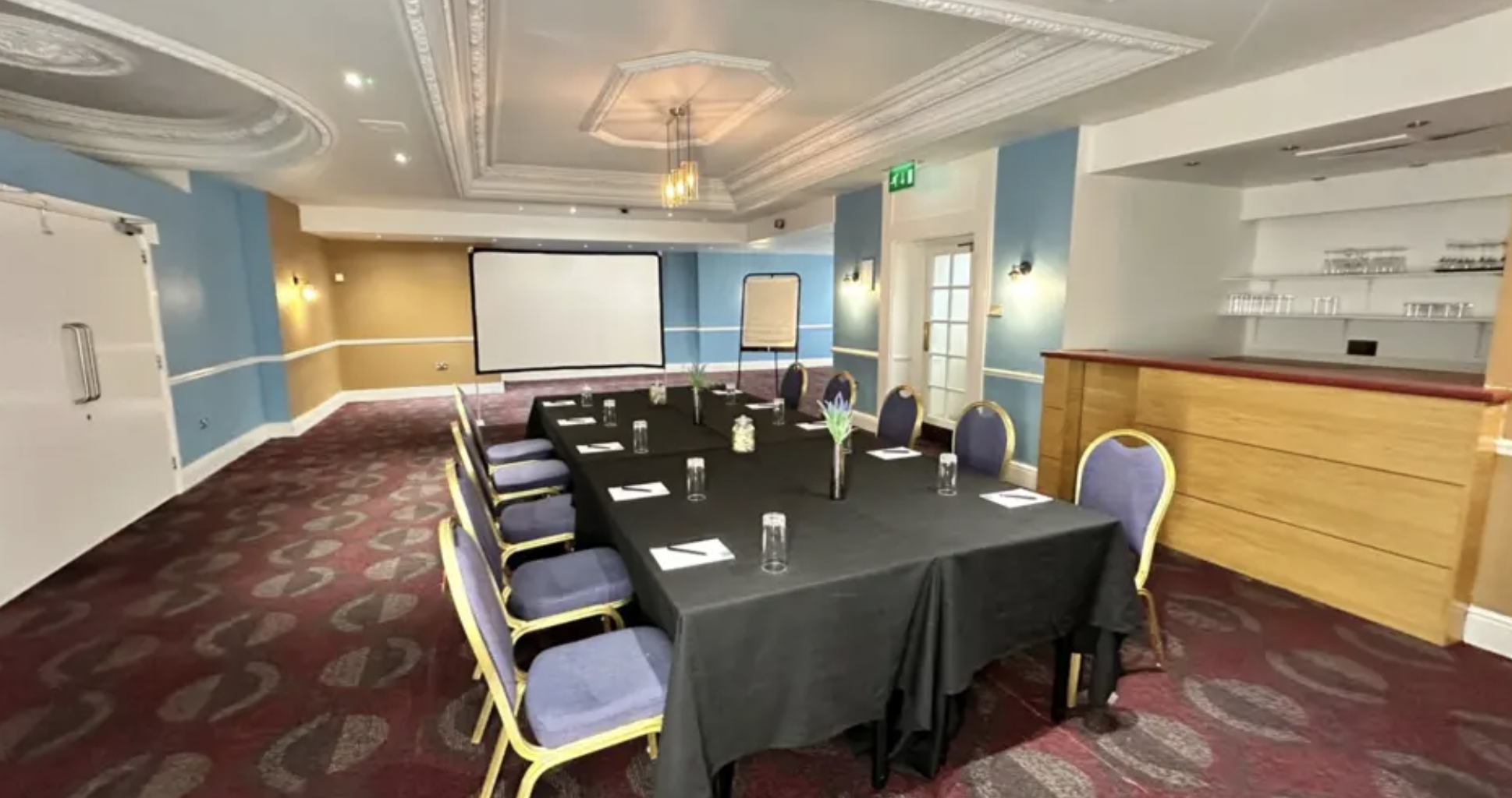 Event space at Carlisle Station Hotel with elegant black linens and purple chairs for meetings.