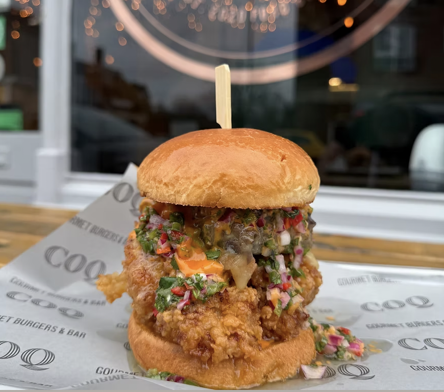 Gourmet burger with fried chicken, ideal for casual dining events in Coq Bristol.