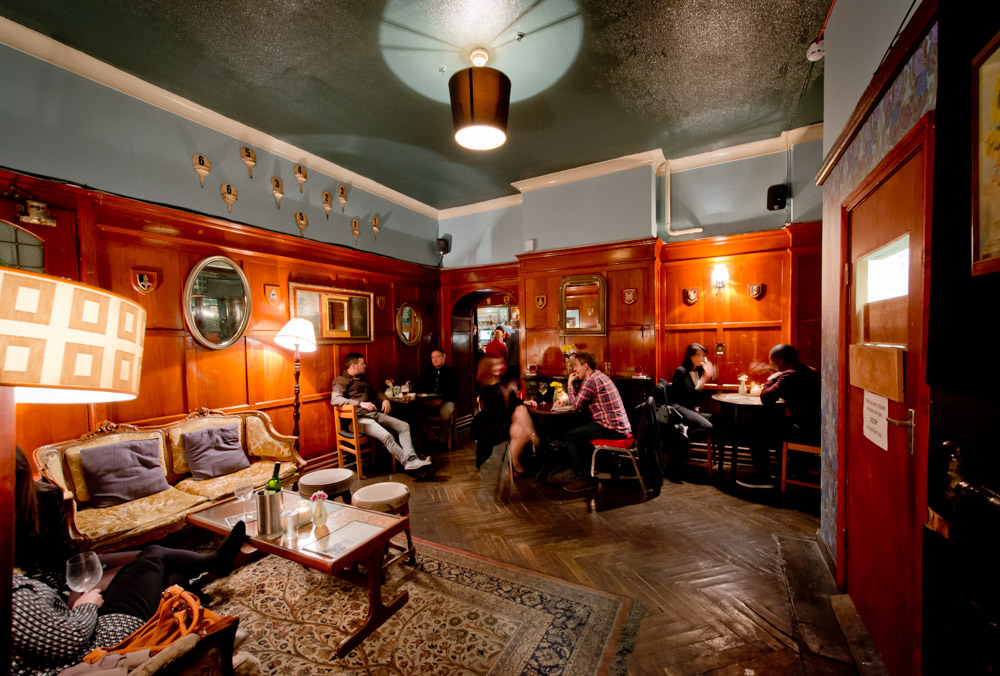 Cozy Balham Bowls Club Lounge with warm wood paneling, perfect for networking events.