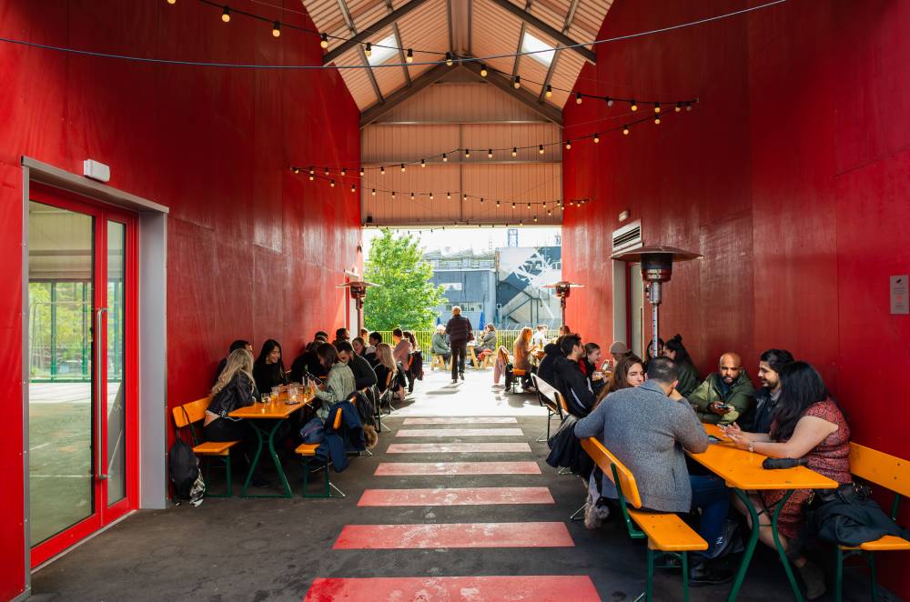 Industrial-chic breakout area with communal bench seating for corporate networking events.