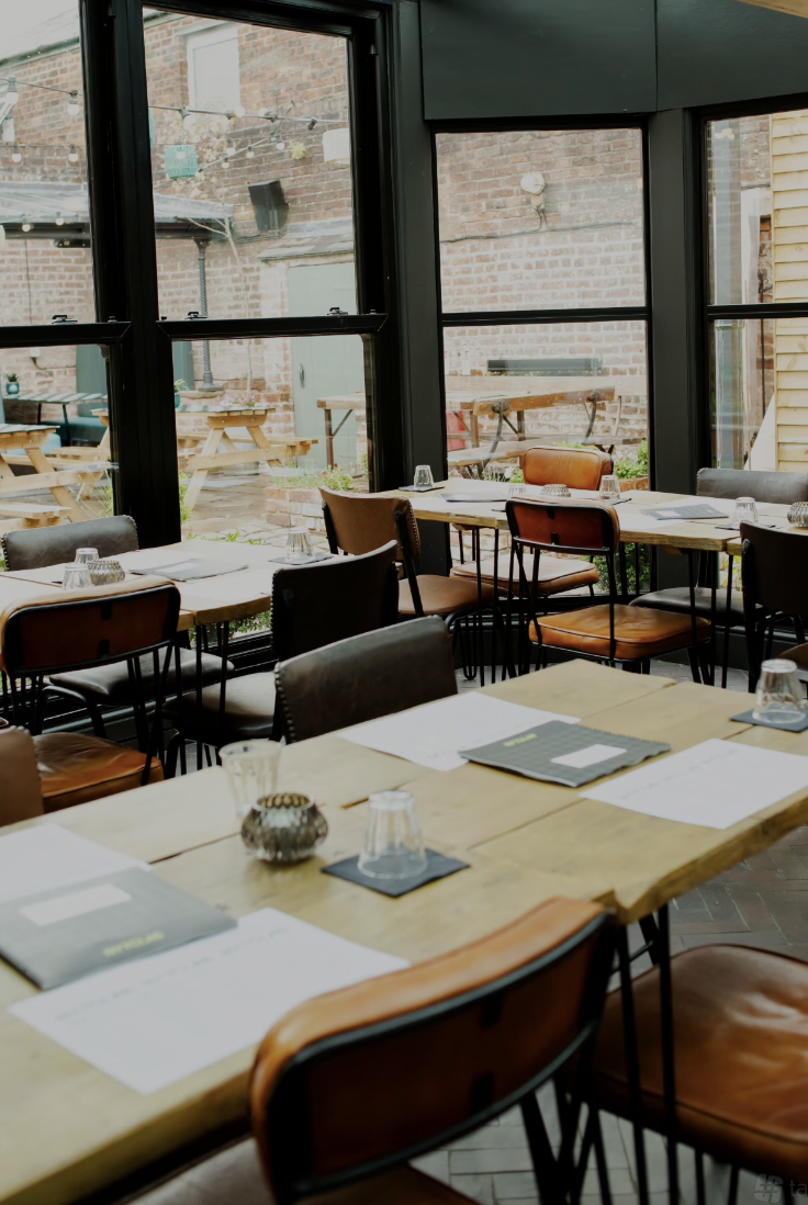 Stylish meeting space for corporate events with wooden tables and natural light.