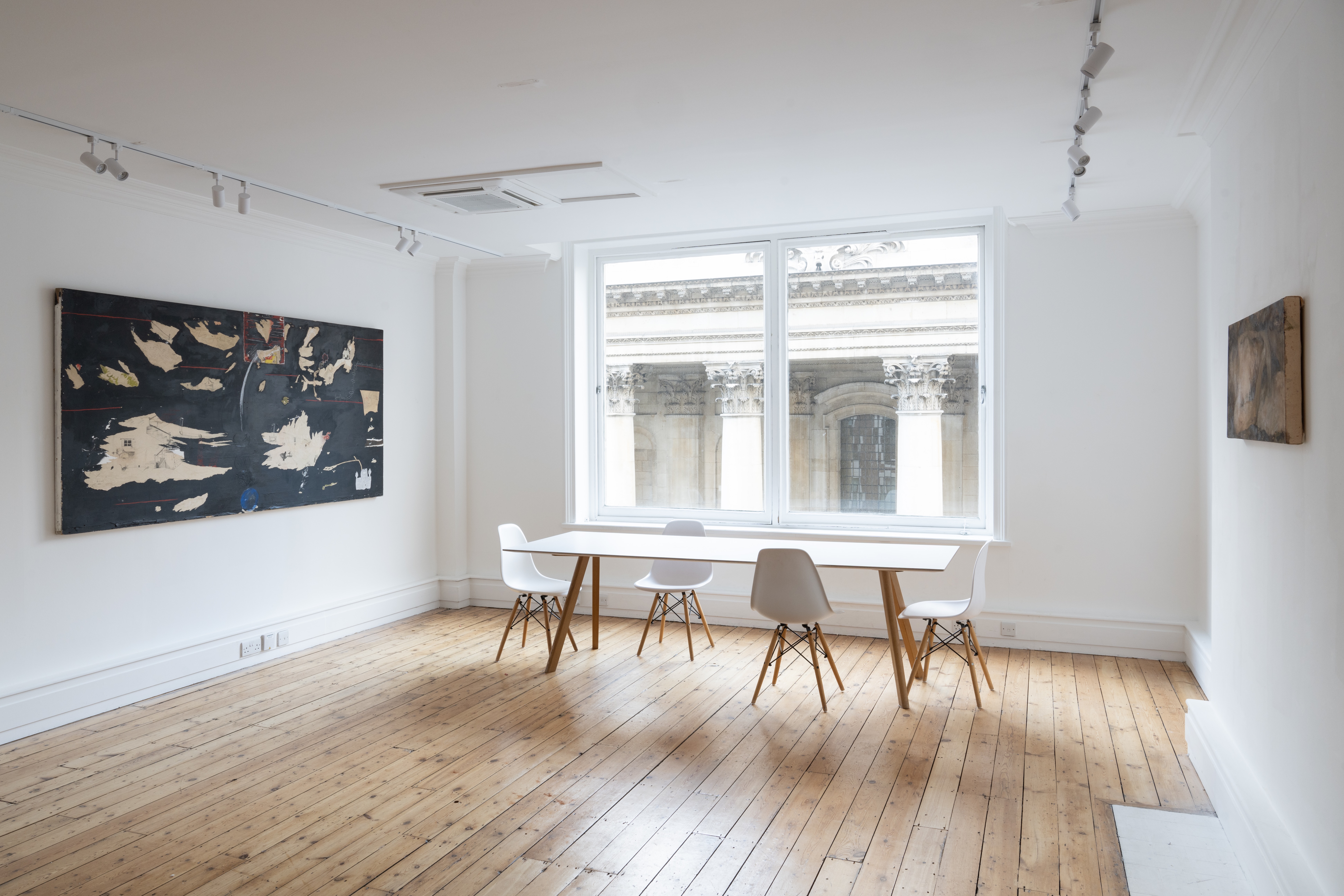 Minimalist meeting room with natural light for intimate gatherings and brainstorming sessions.