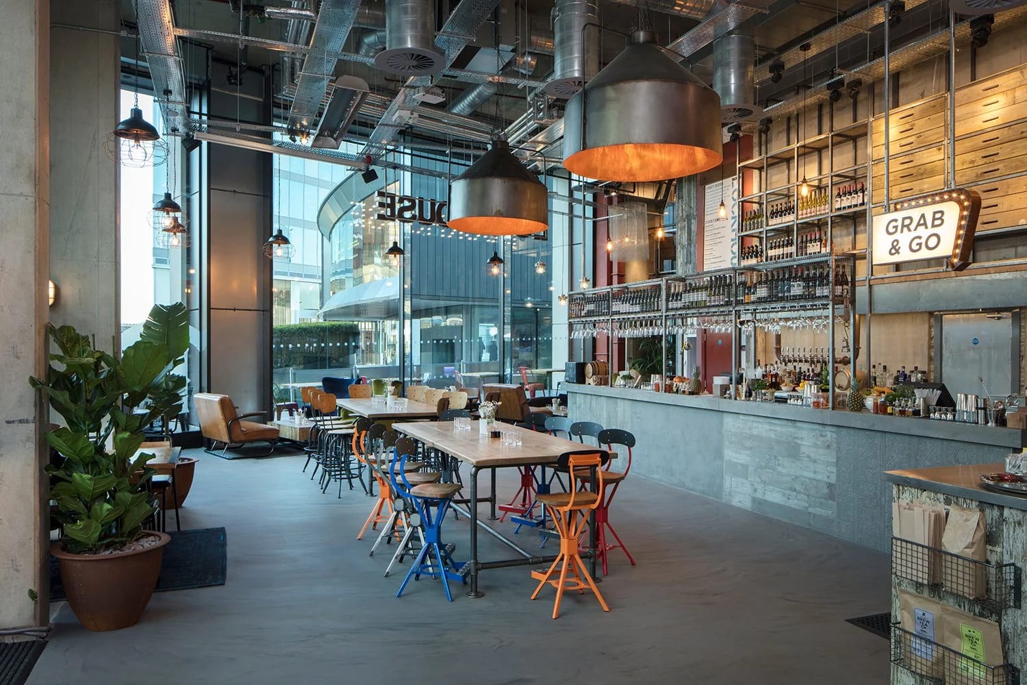 Modern café space for networking events, featuring large windows and ample seating.