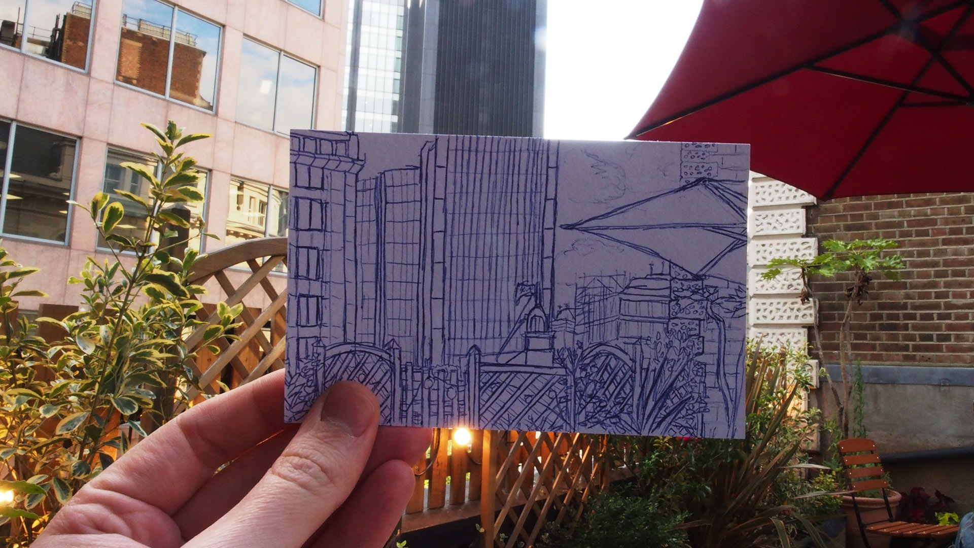 Hand holding sketch of Roof Terrace, modern urban venue for networking events.