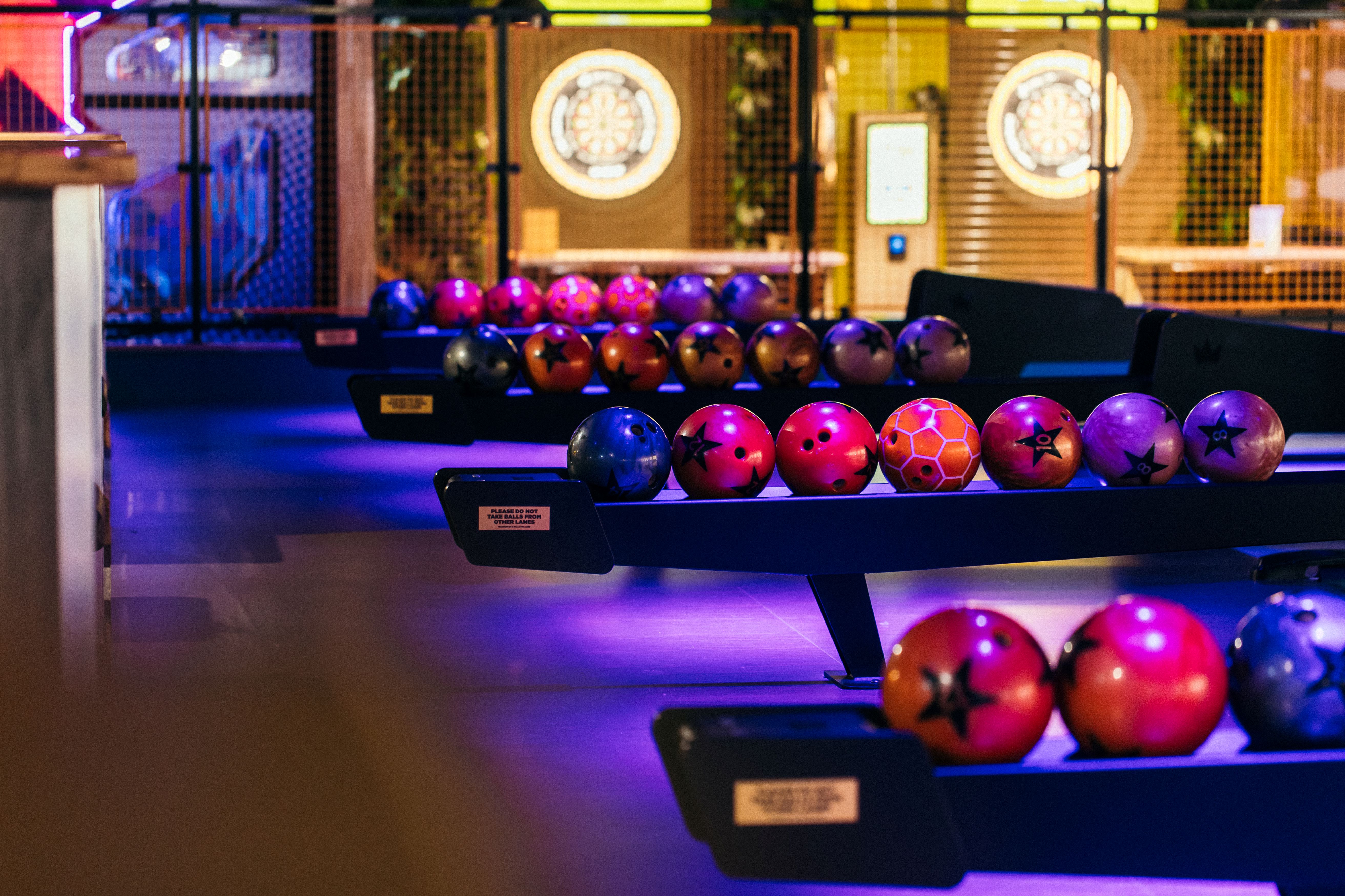 Vibrant bowling alley with colorful balls, perfect for team-building and events in Belfast.
