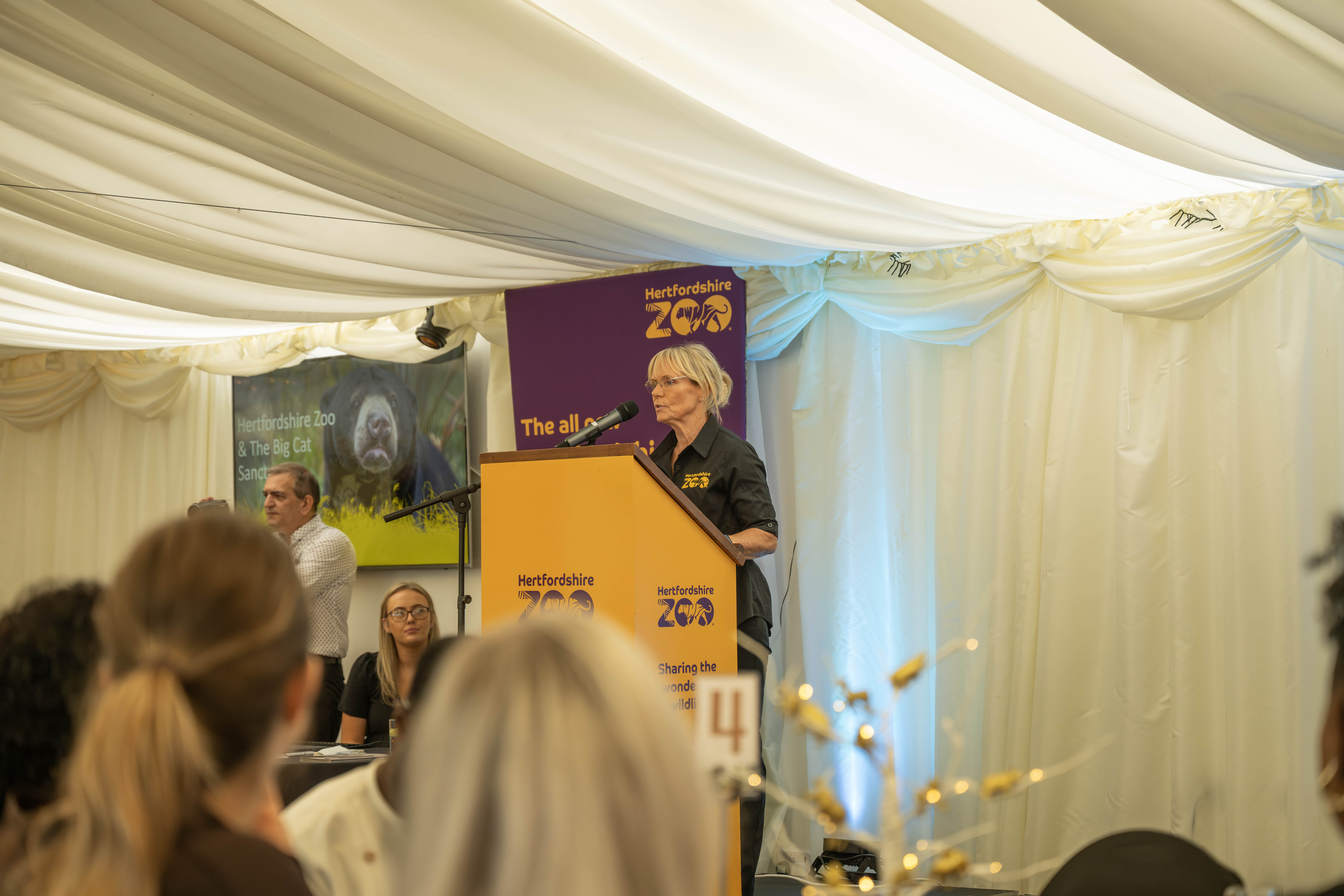 Elegant conference setup at Hertfordshire Zoo with speaker engaging audience.