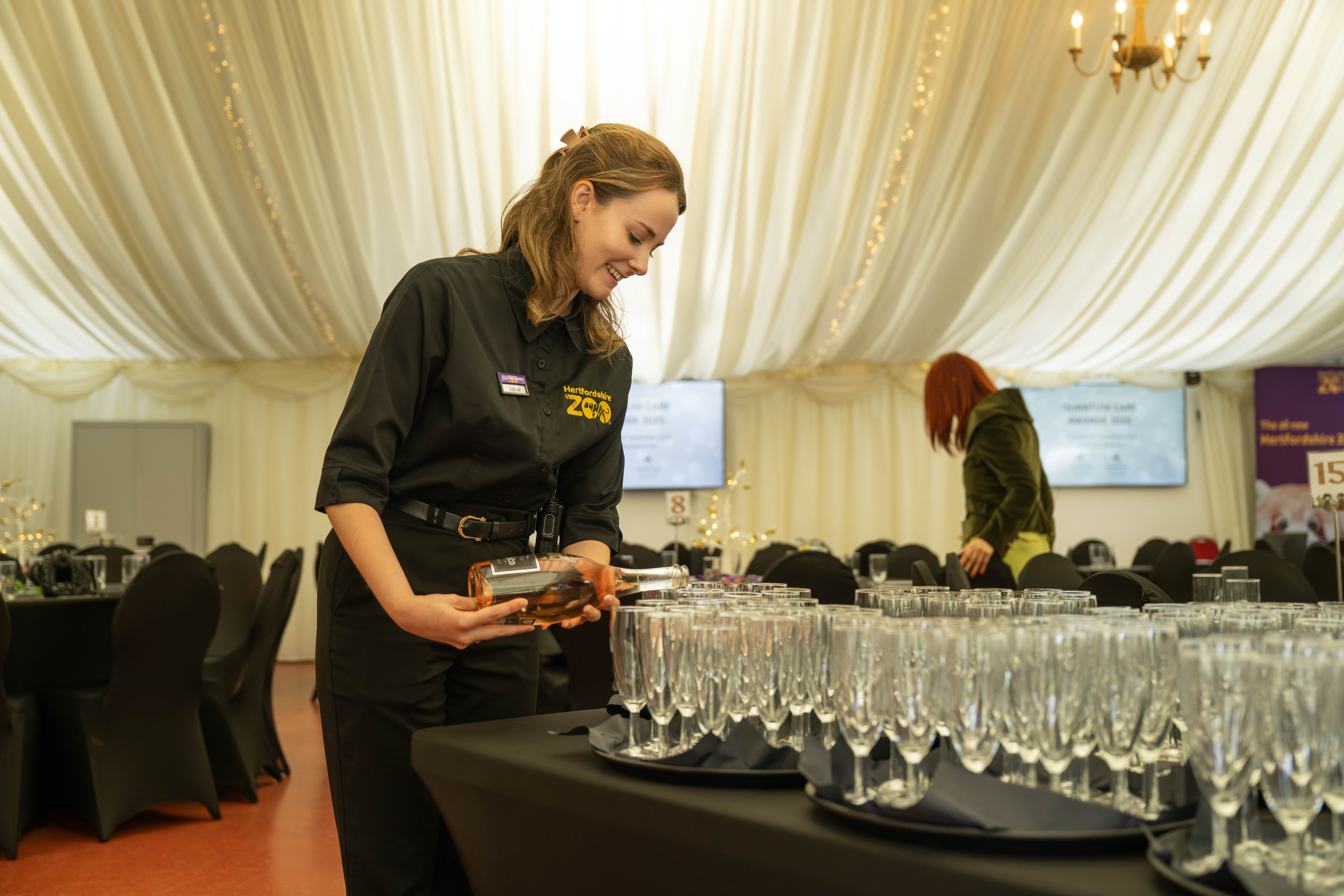 Event setup at Hertfordshire Zoo with elegant table settings and glassware preparation.