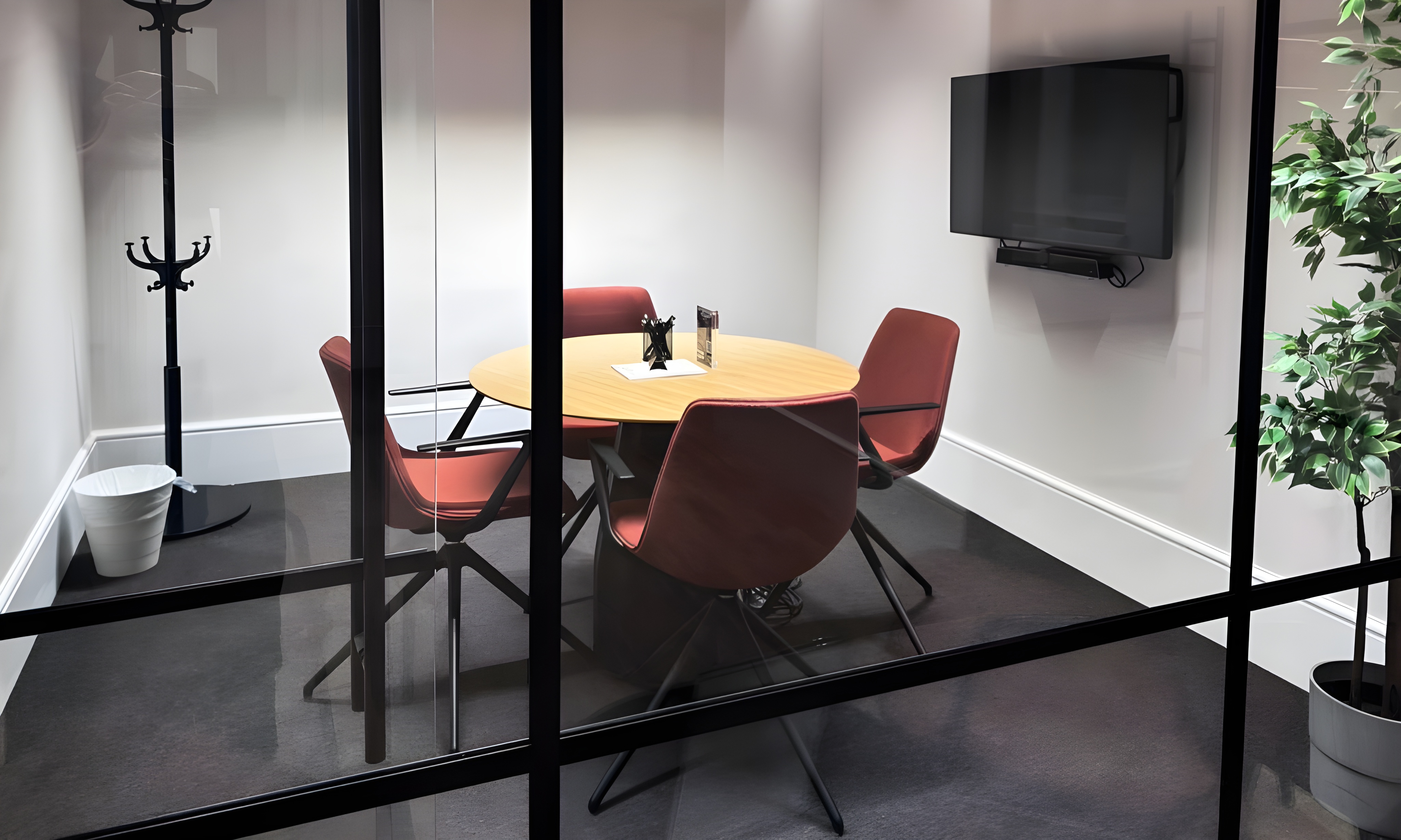 Modern meeting room in MYCO with glass walls for collaborative brainstorming sessions.