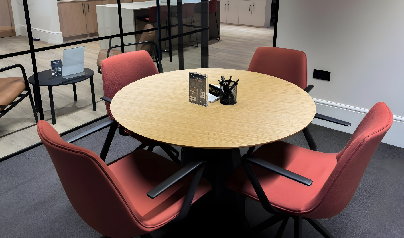 Modern meeting space with round table and orange chairs for collaborative brainstorming.