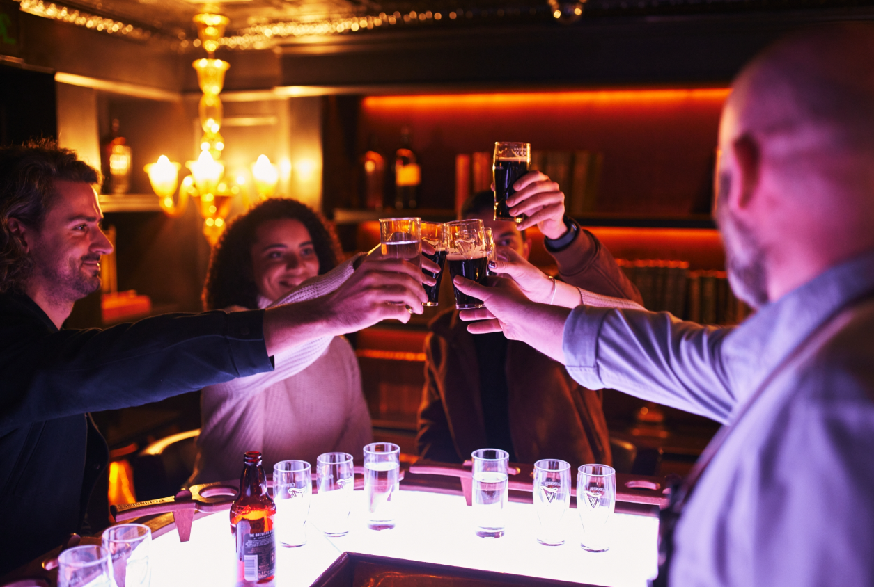 Colleagues toasting in cozy Bottle Room at Guinness Open Gate Brewery, ideal for corporate events.