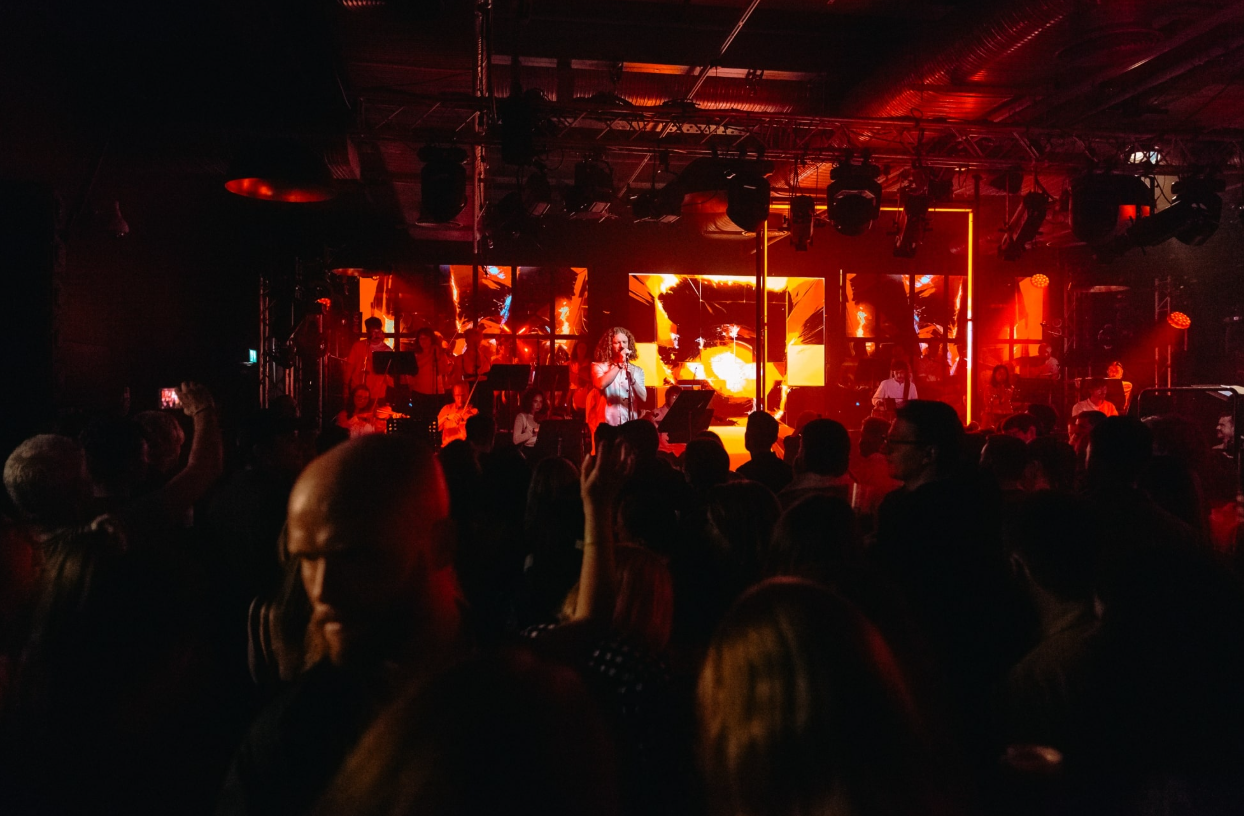 Guinness Open Gate Brewery event with dynamic stage, colorful lights, and engaged audience.