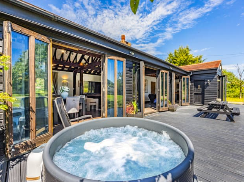 Essex Barn House outdoor space with hot tub, ideal for retreats and gatherings.