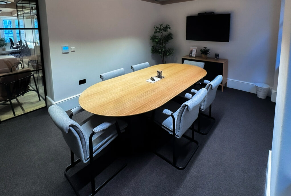 Sleek conference room with wooden table, ideal for meetings and brainstorming sessions.