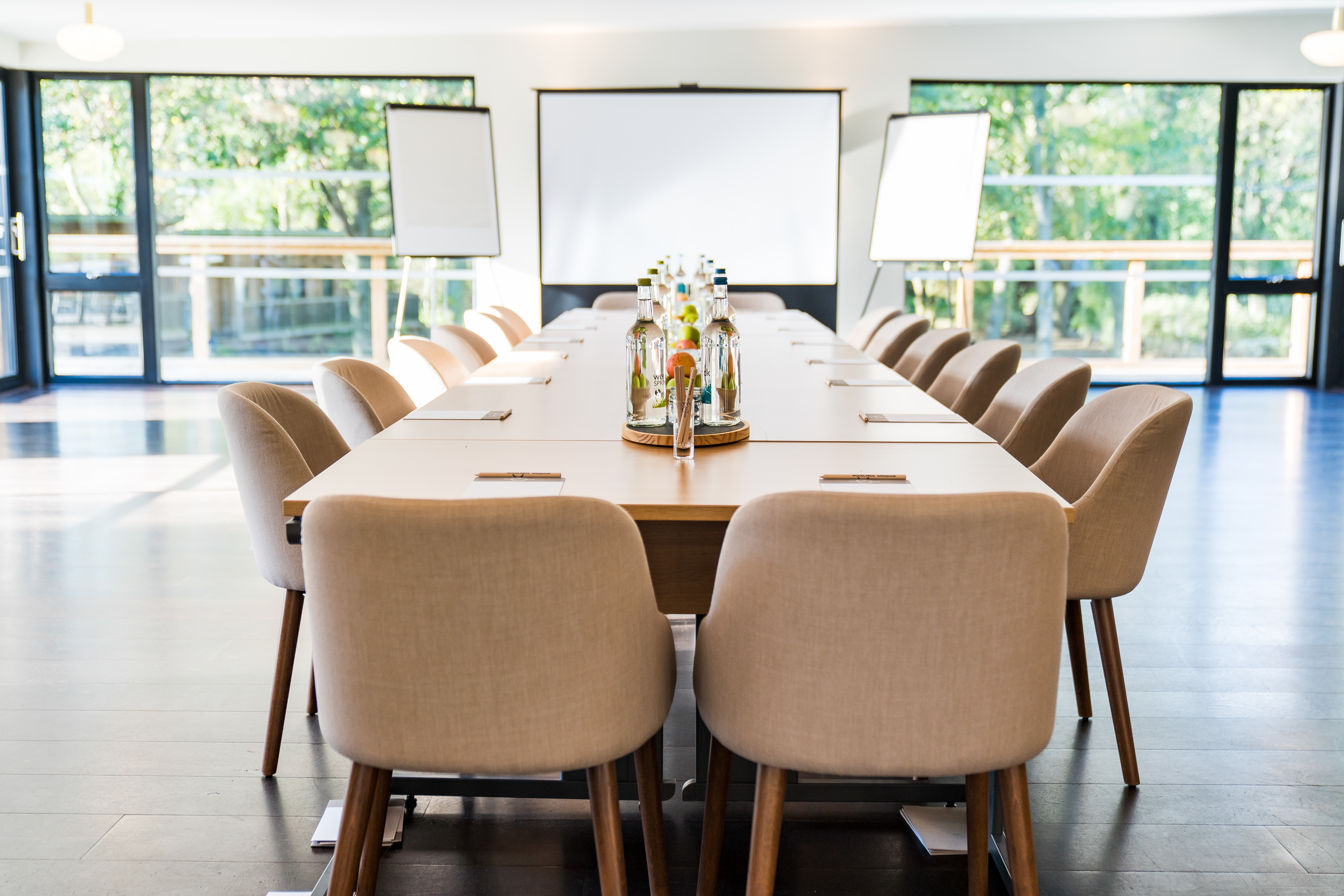 Modern meeting space with wooden table, perfect for collaboration and brainstorming events.
