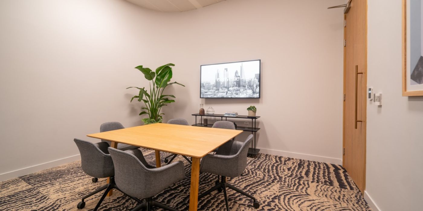 Modern meeting room with central wooden table, ideal for corporate events and collaboration.