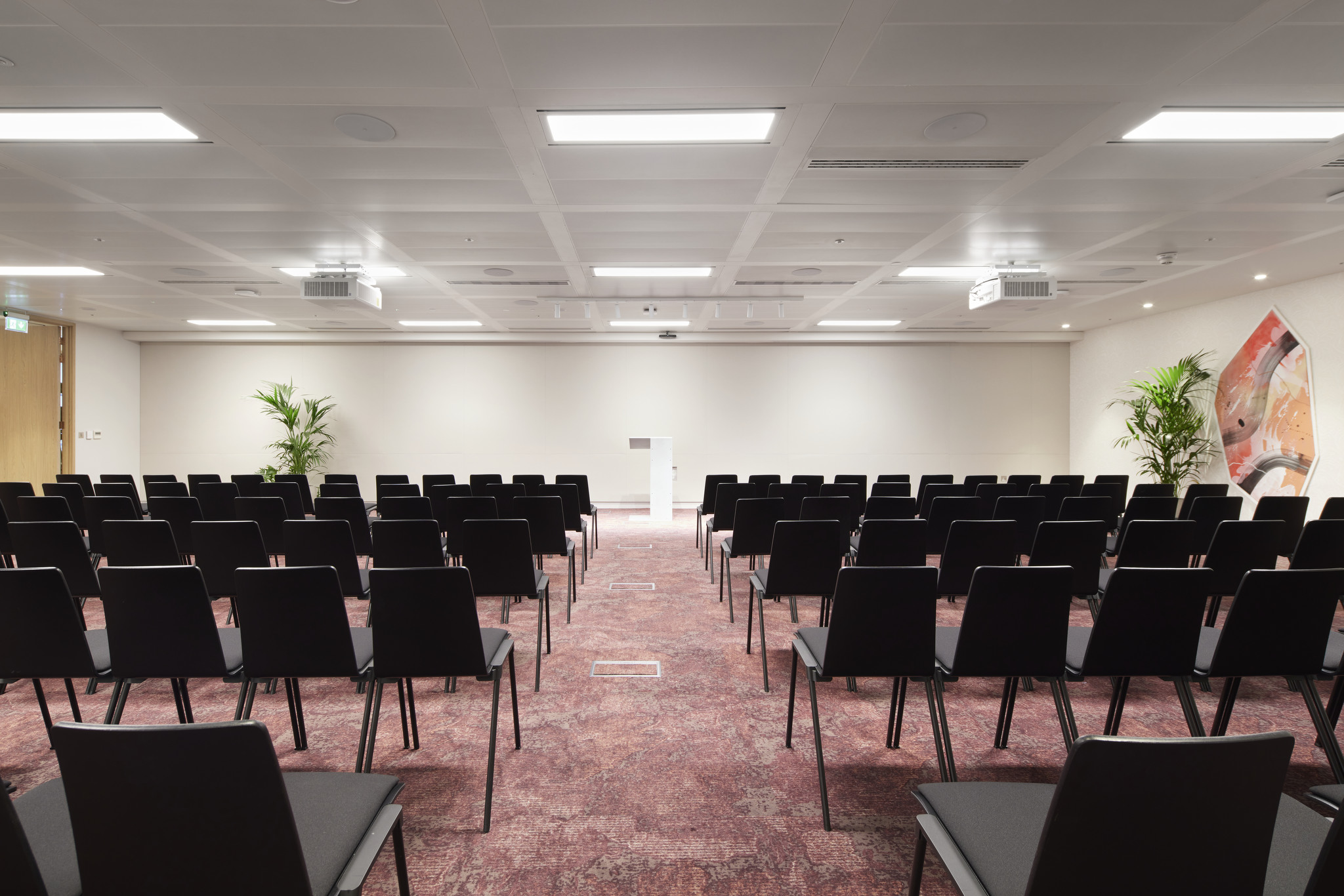 Bon Hub event space with black chairs, ideal for conferences and presentations.