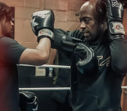 Boxing training session in fitness gym, showcasing teamwork and dedication.