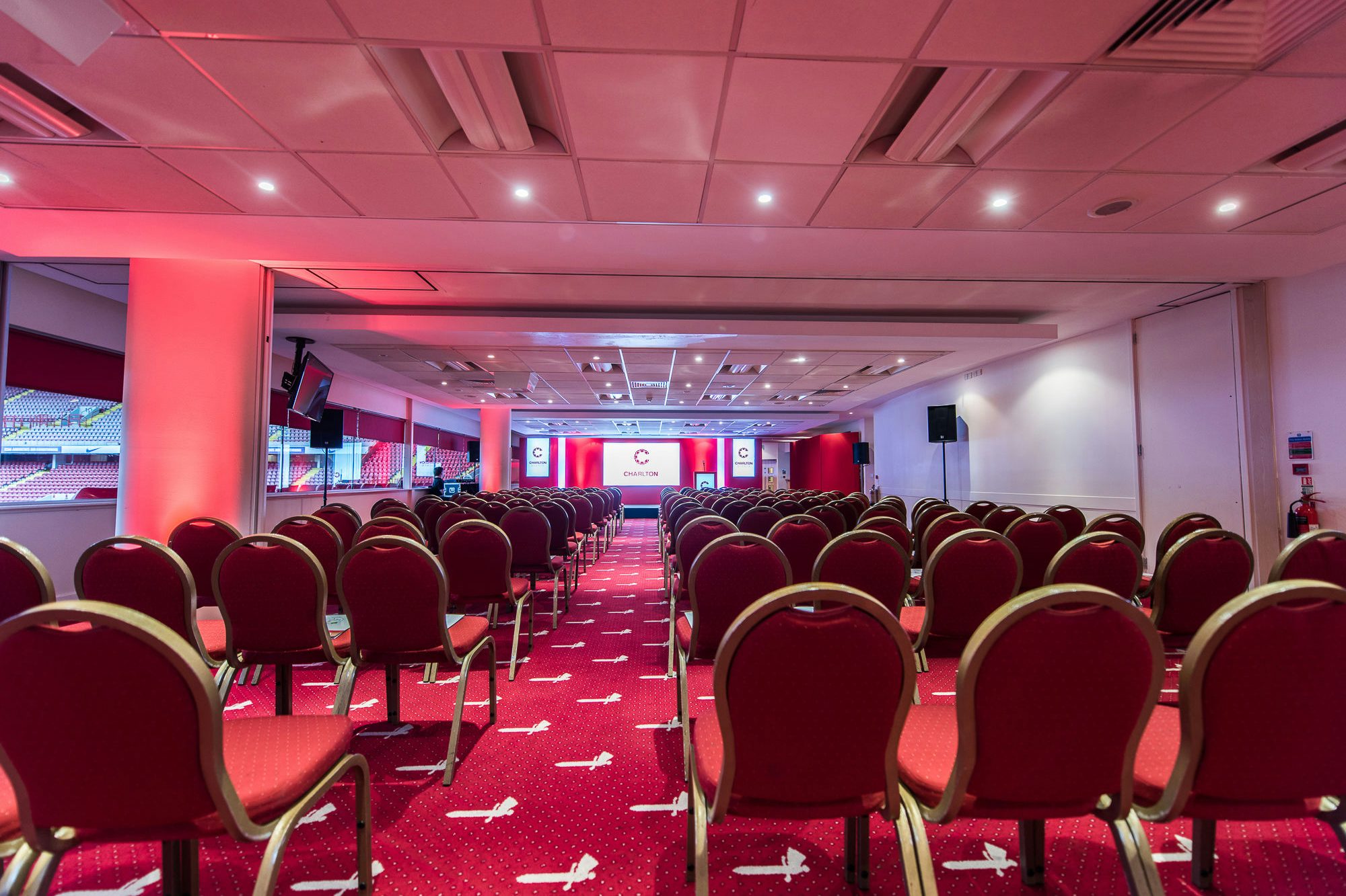 North Stand Suite at Charlton Athletic: Red chairs set for corporate events and presentations.