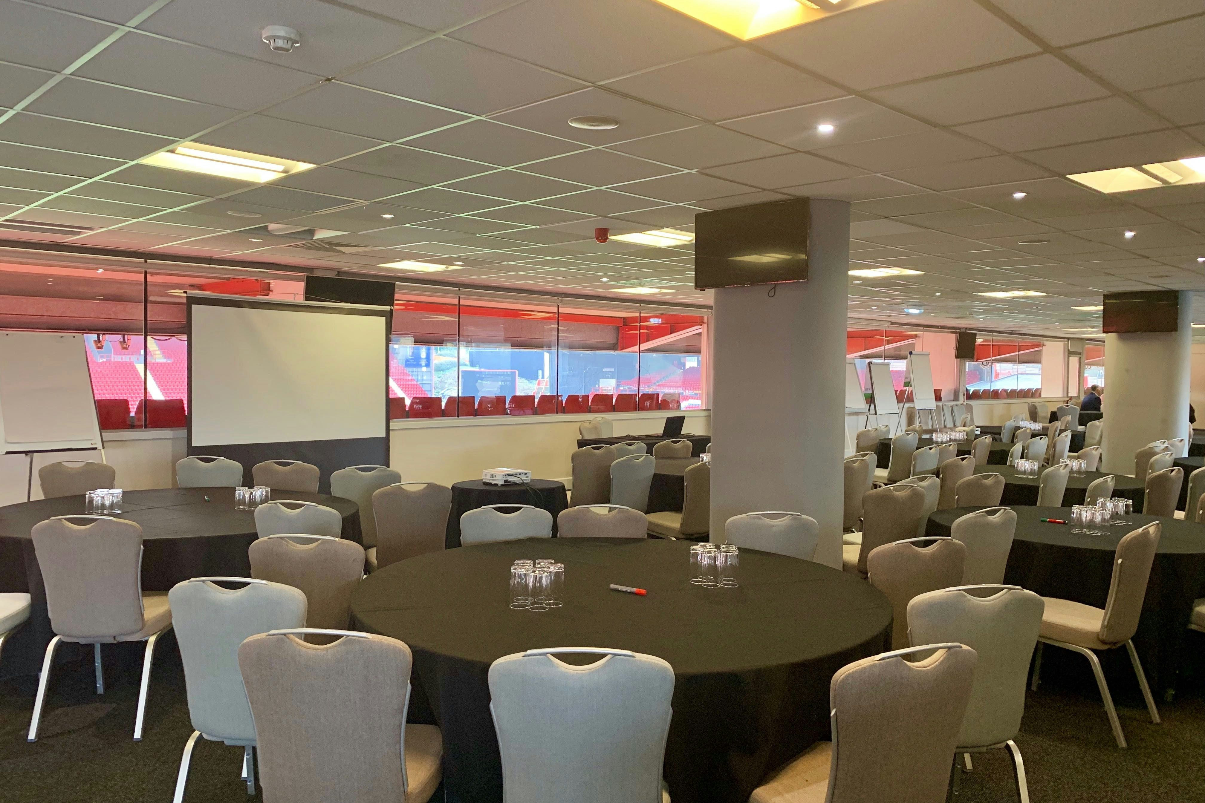 Club 1905 Lounge: elegant meeting space with round tables, perfect for corporate events and workshops.