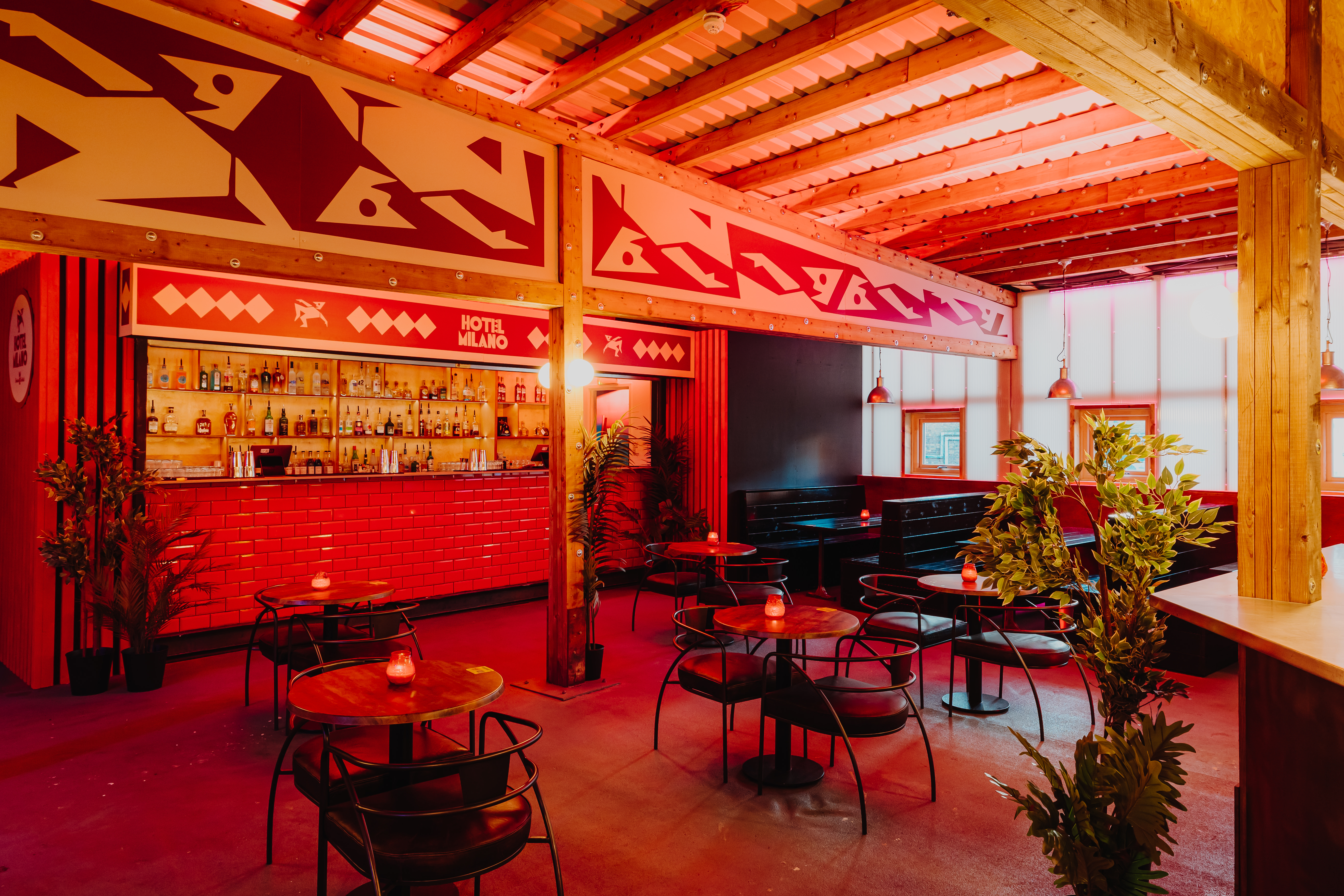 Hotel Milano Bar in Freight Brixton: vibrant red lounge for networking and corporate events.