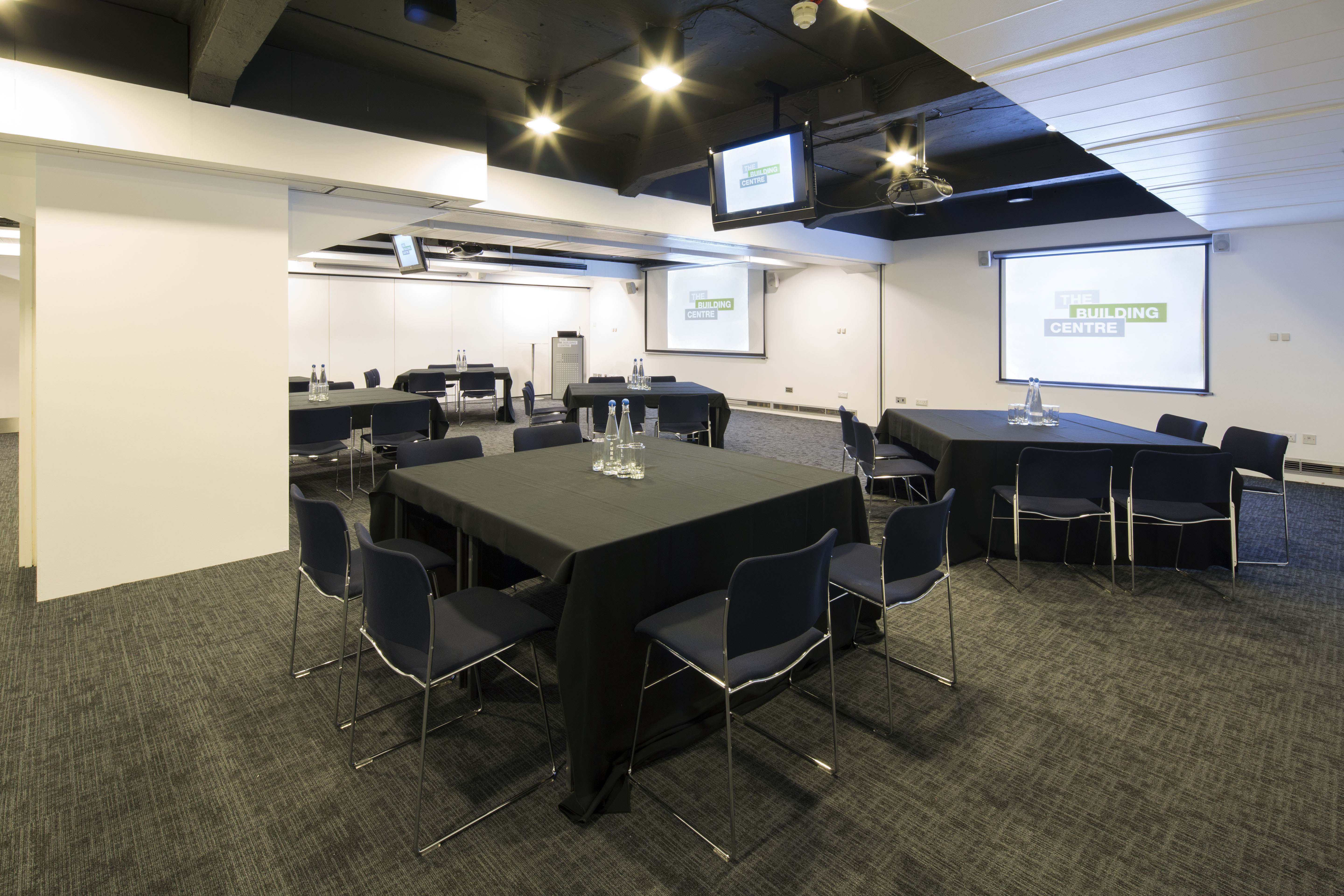 Modern Seminar Suites with tables and presentation screens for corporate events.