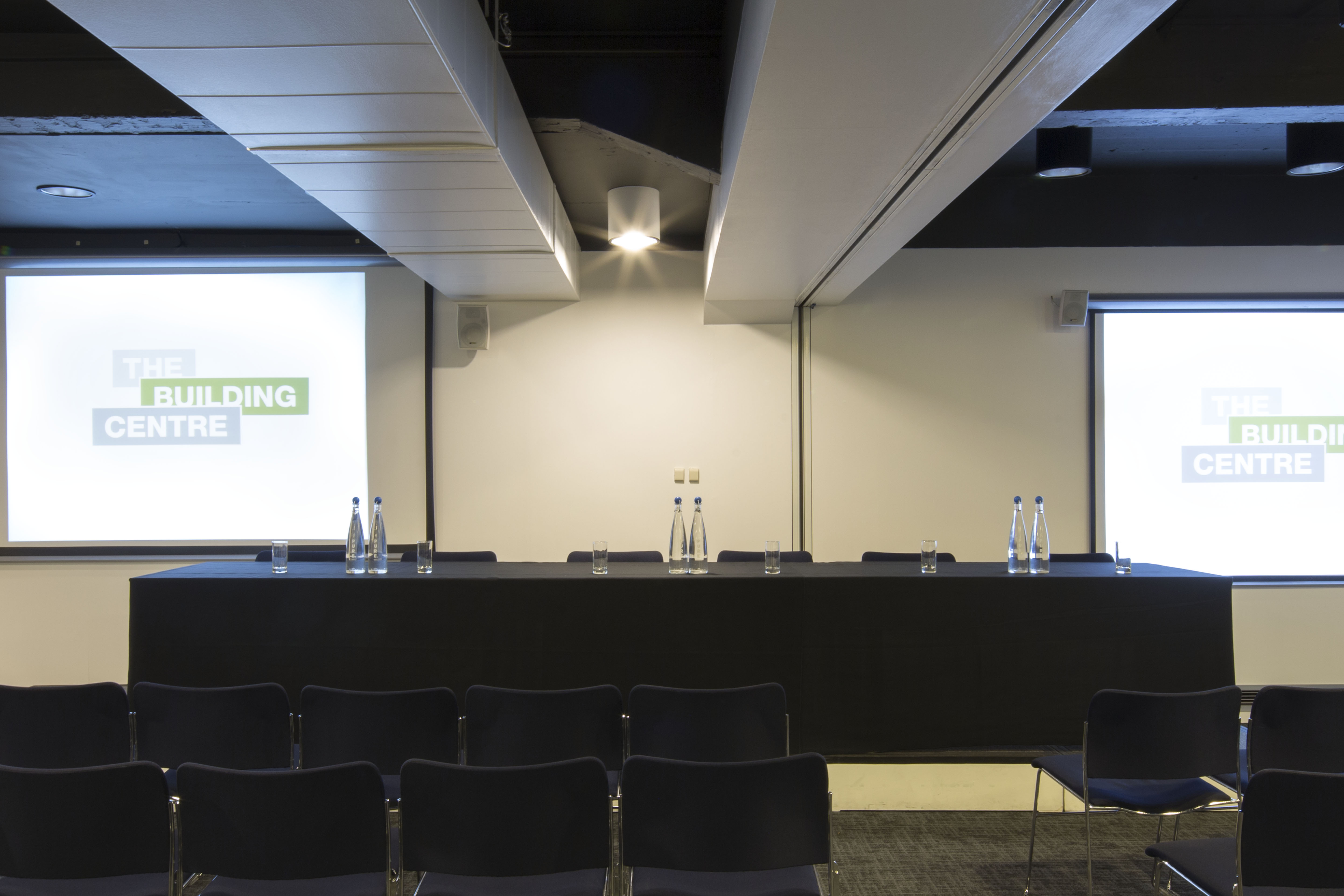 Professional meeting space with long table for panel discussions, ideal for seminars or presentations.