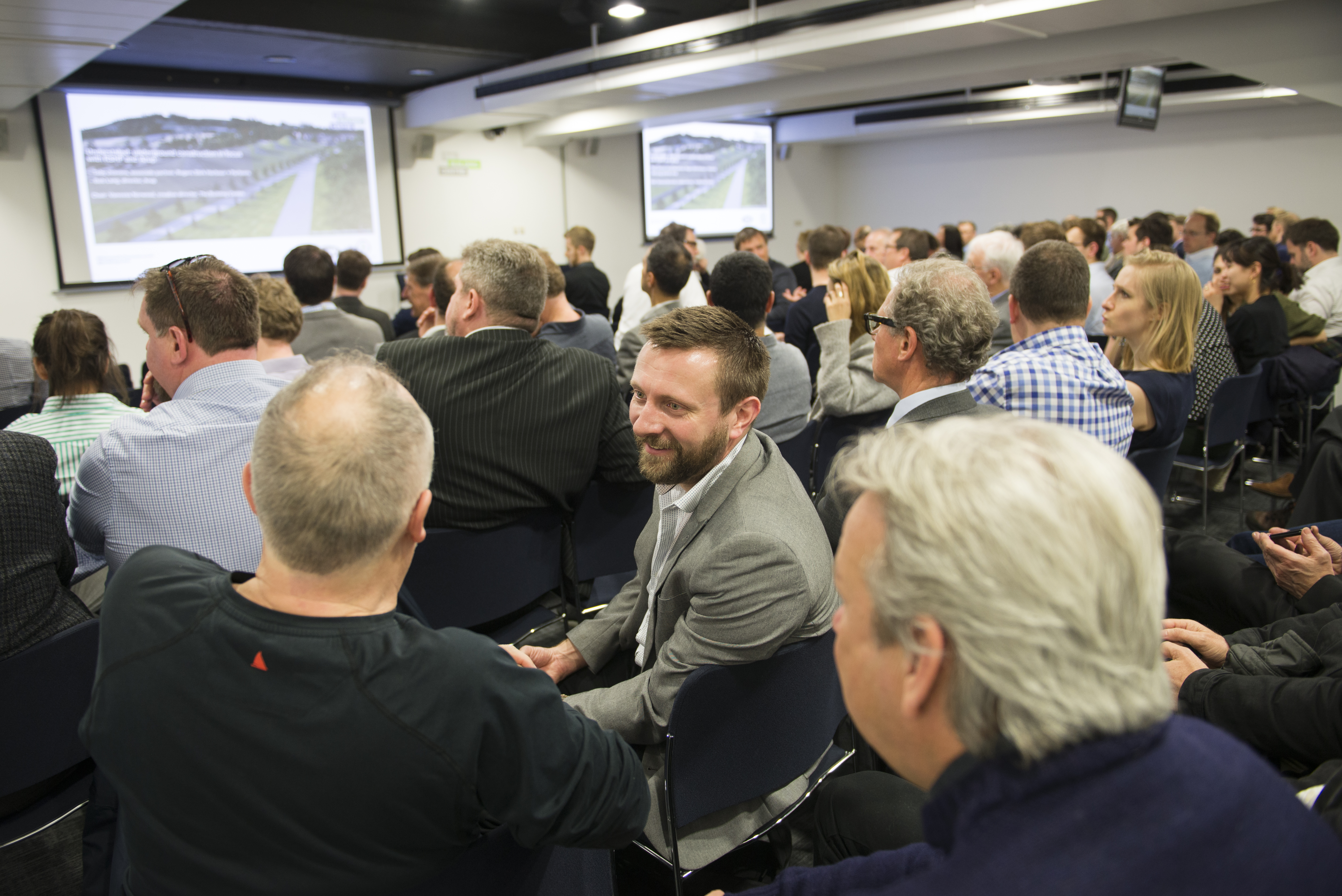 Conference in modern Seminar Suites with engaged audience and effective lighting.