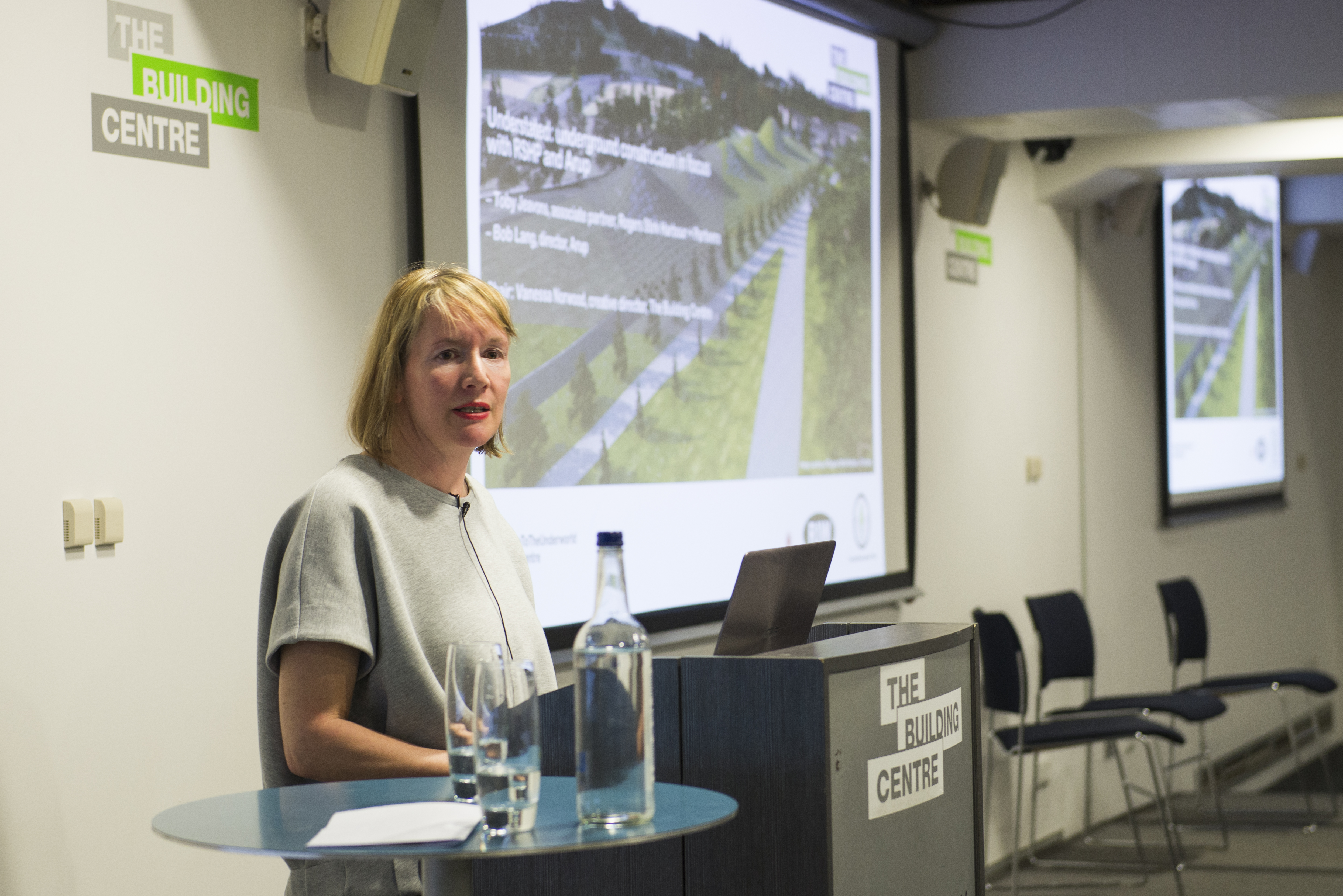 Professional speaker at podium in Seminar Suites, engaging audience at educational event.