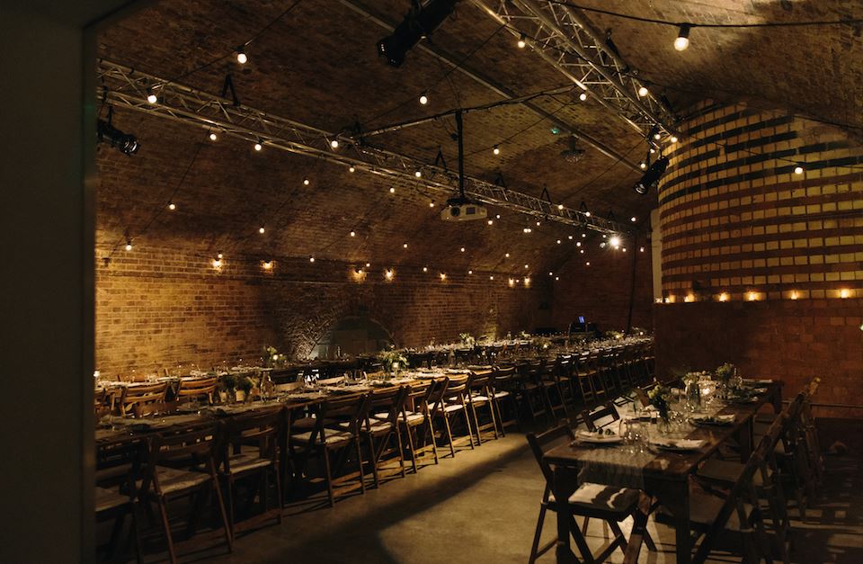 "Charming Kachette venue with wooden tables and ambient lighting for events and gatherings."