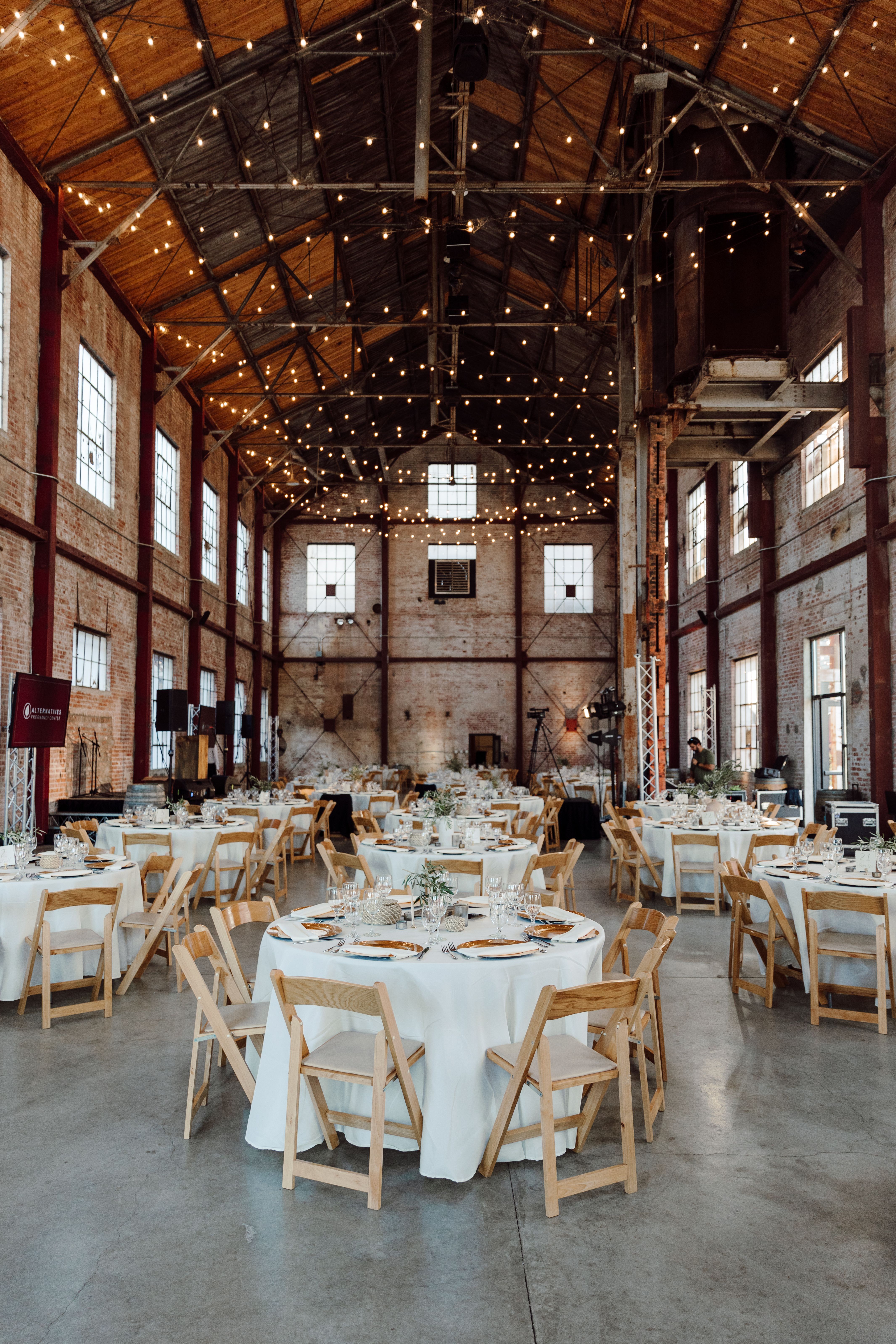 Elegant wedding venue with exposed brick walls and warm string lights. Perfect for events.