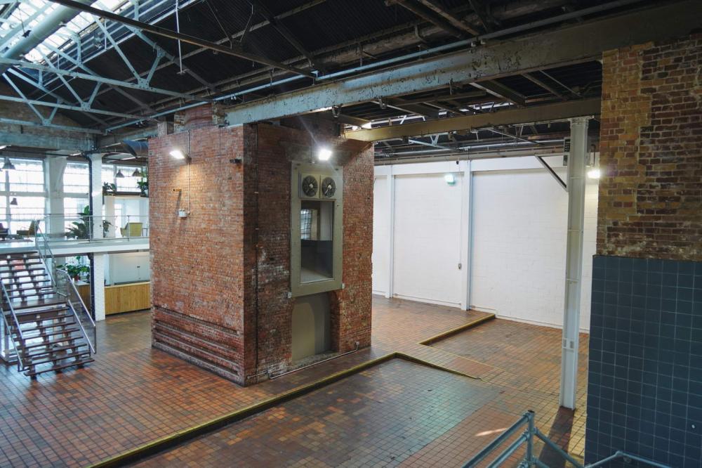 Spacious industrial venue with exposed brick for corporate events and social gatherings.