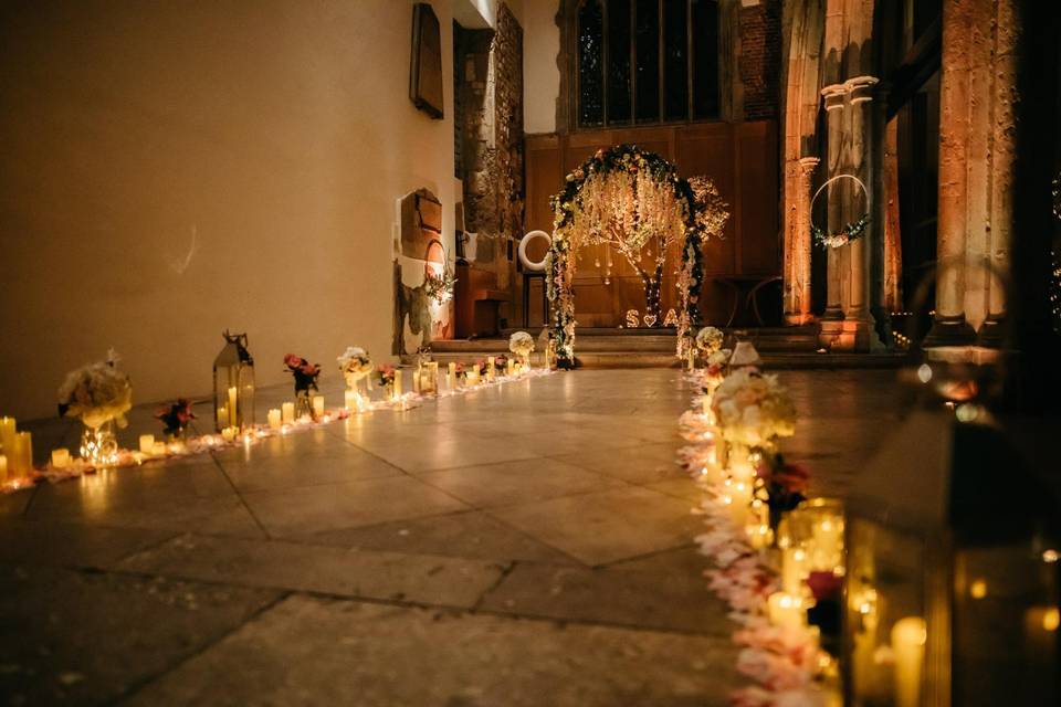 Candlelit St Ethelburga's Nave, a romantic wedding venue with elegant decor and floral arrangements.