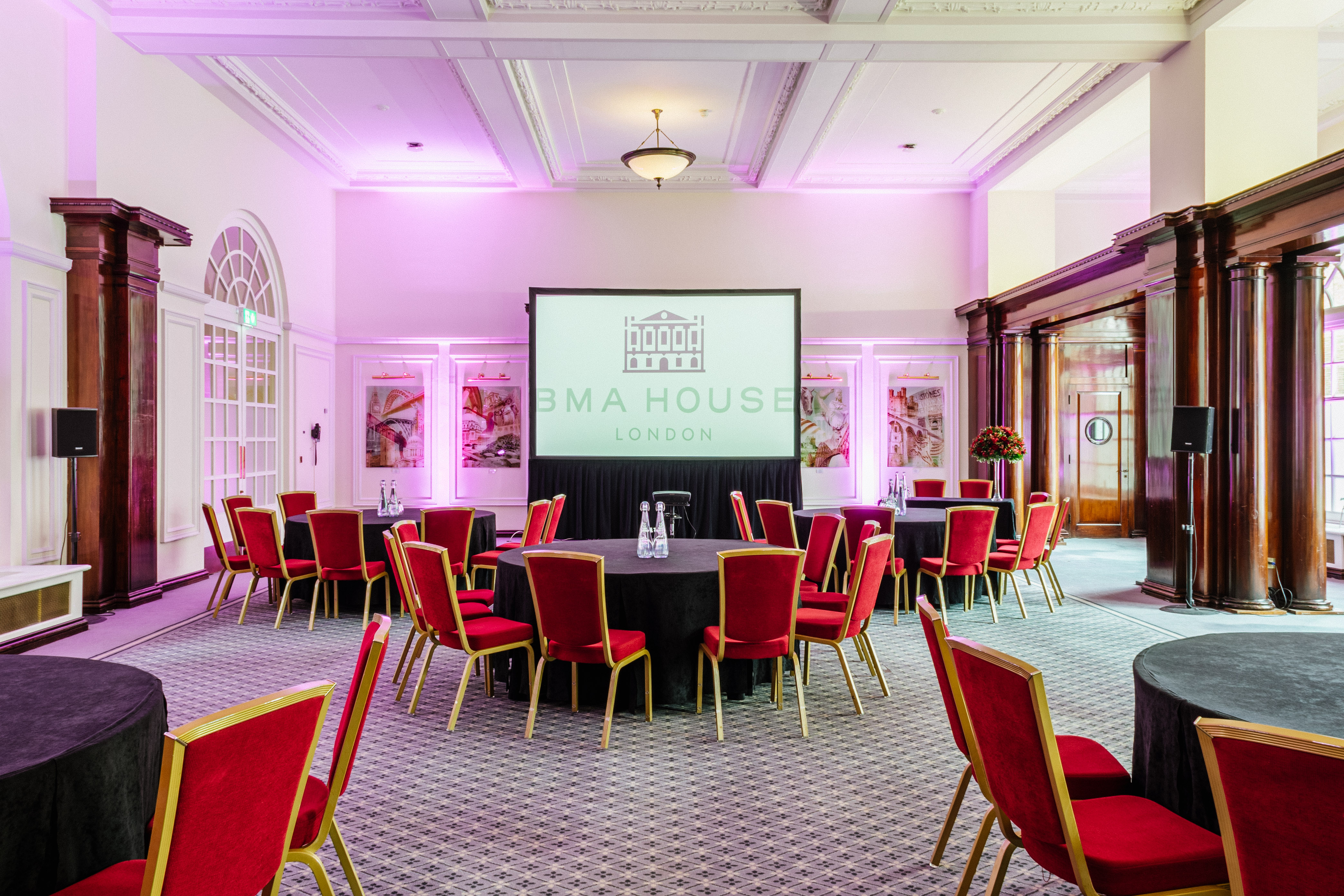 Low-Impact DDR event setup with elegant round tables and presentation screen at BMA House.
