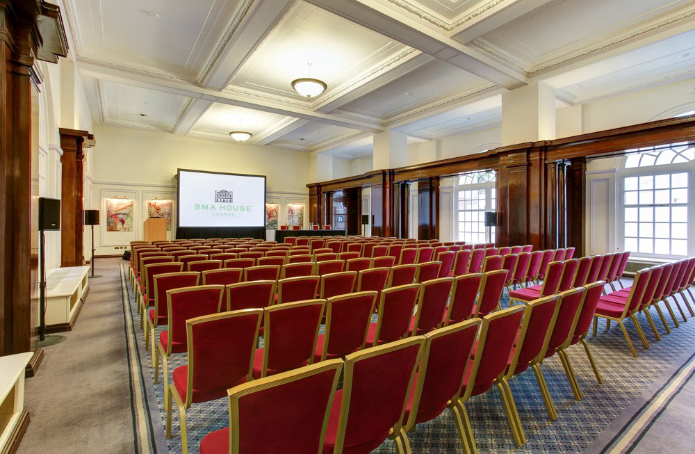 Low-Impact DDR event space with red theater chairs and large screen for presentations.