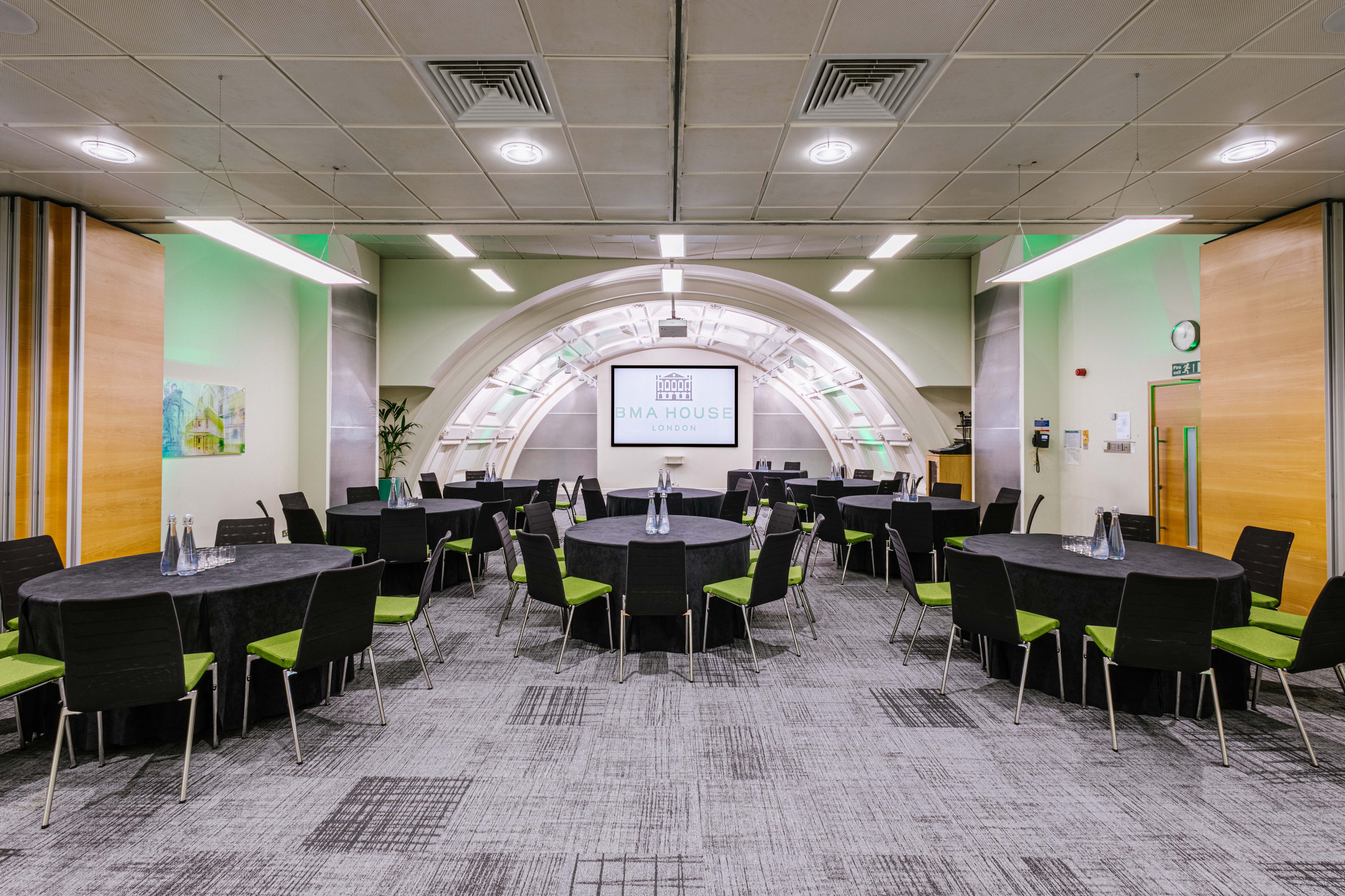 Low-Impact DDR meeting space with round tables in BMA House, perfect for workshops and conferences.